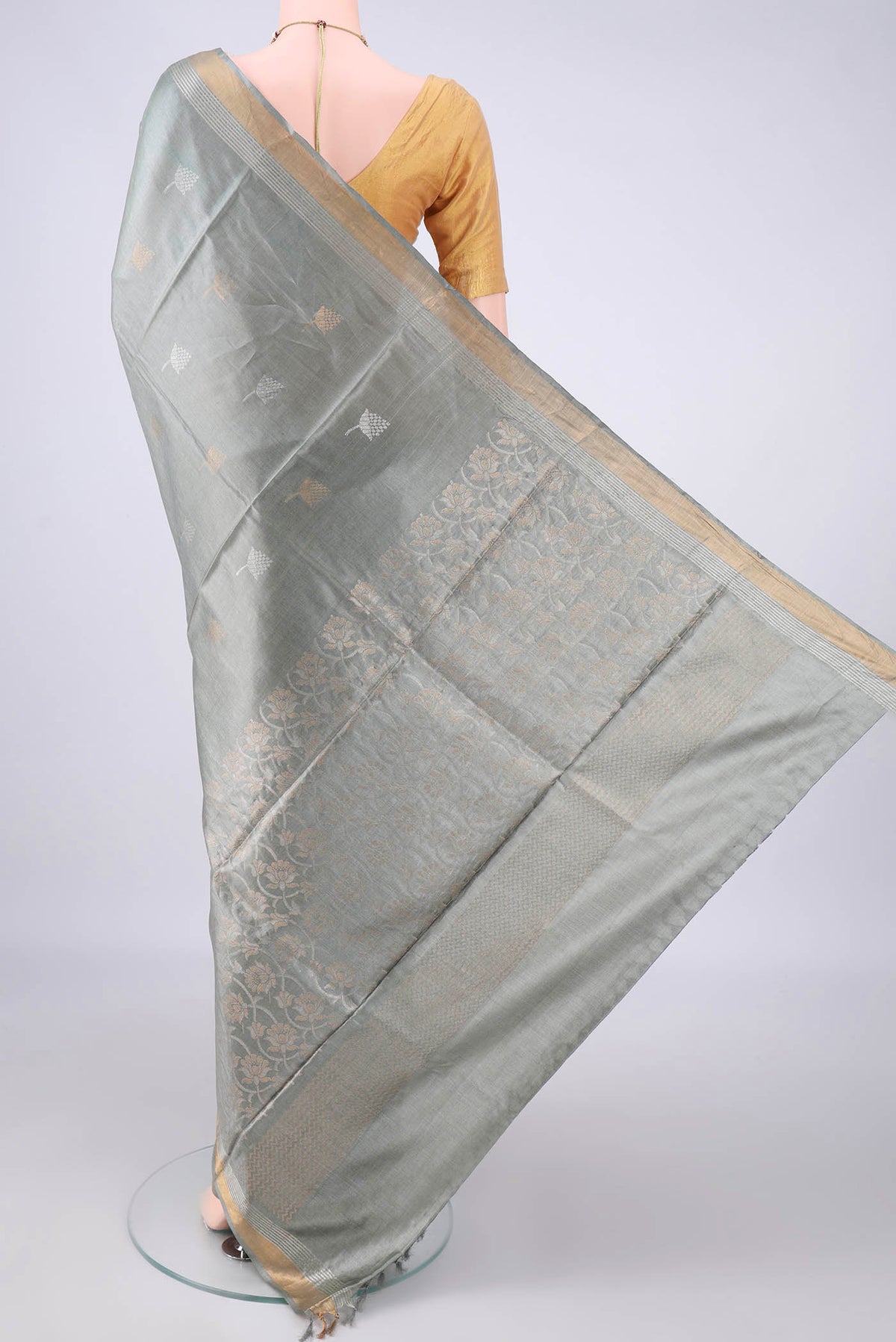 Flat view of Davys Grey MP Tussar Saree with Zari Butta on the body and Zari Border. 