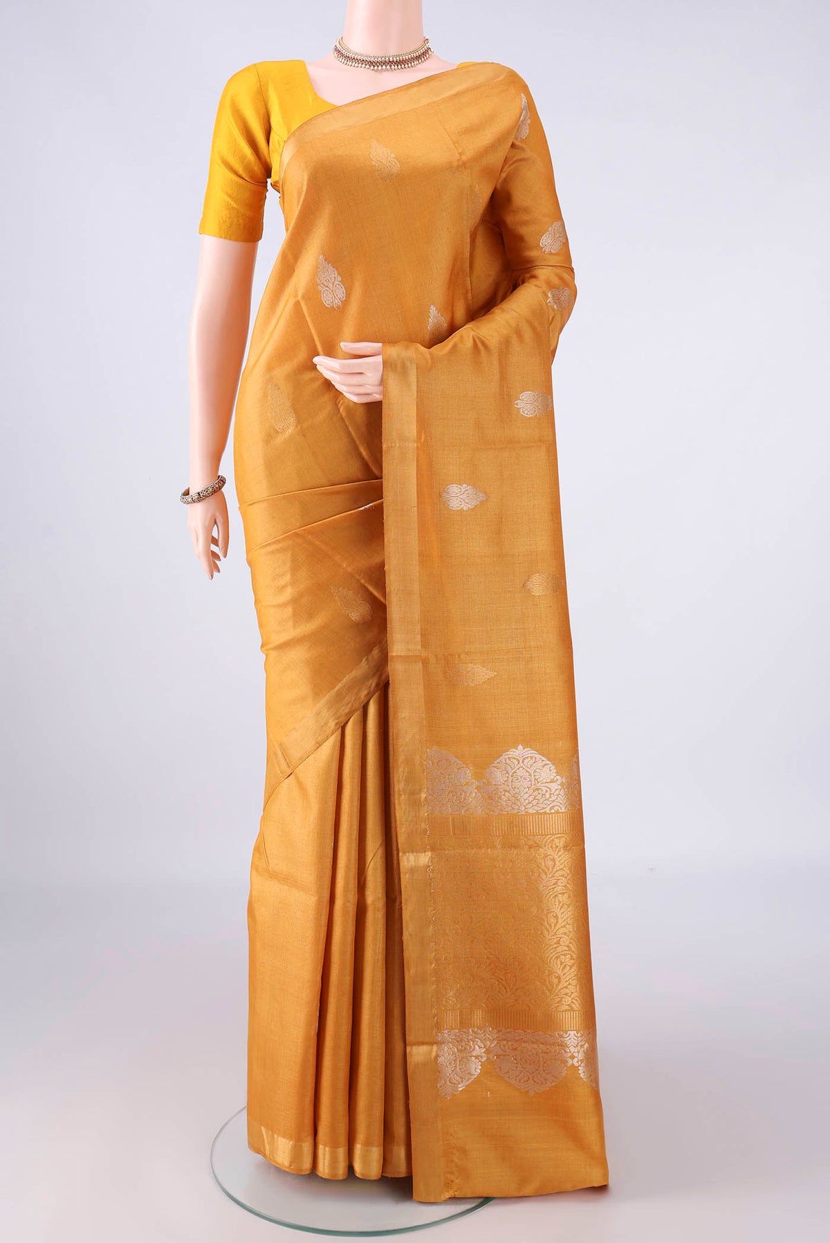 Mustard Tussar Saree with Zari Butta on the body and Zari Border.  displayed on a mannequin