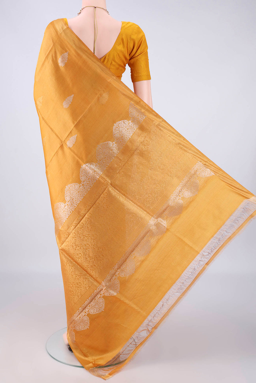Flat view of Mustard Tussar Saree with Zari Butta on the body and Zari Border. 