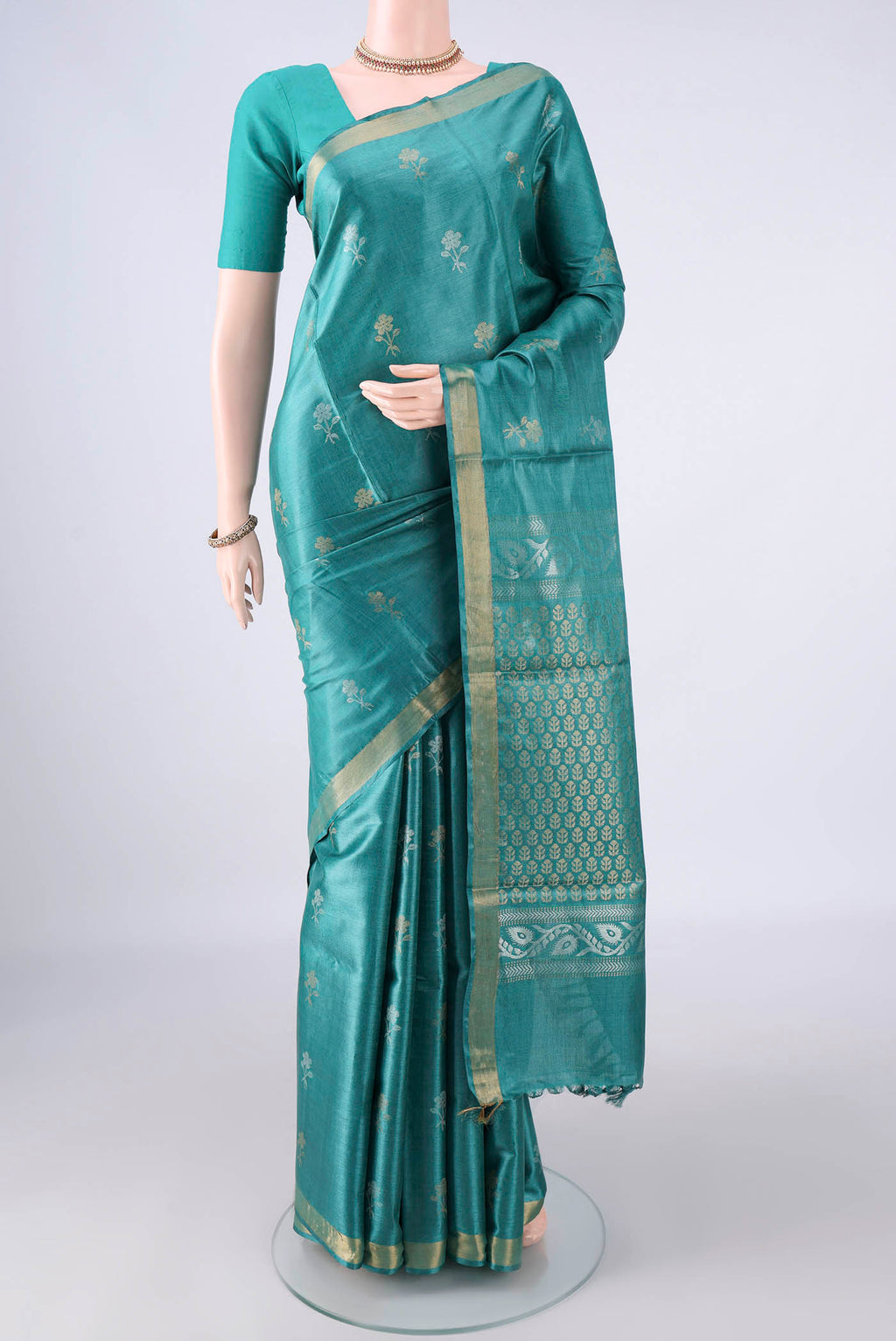 Sea Green Tussar Saree with Zari Butta on the body and Zari Border.  displayed on a mannequin