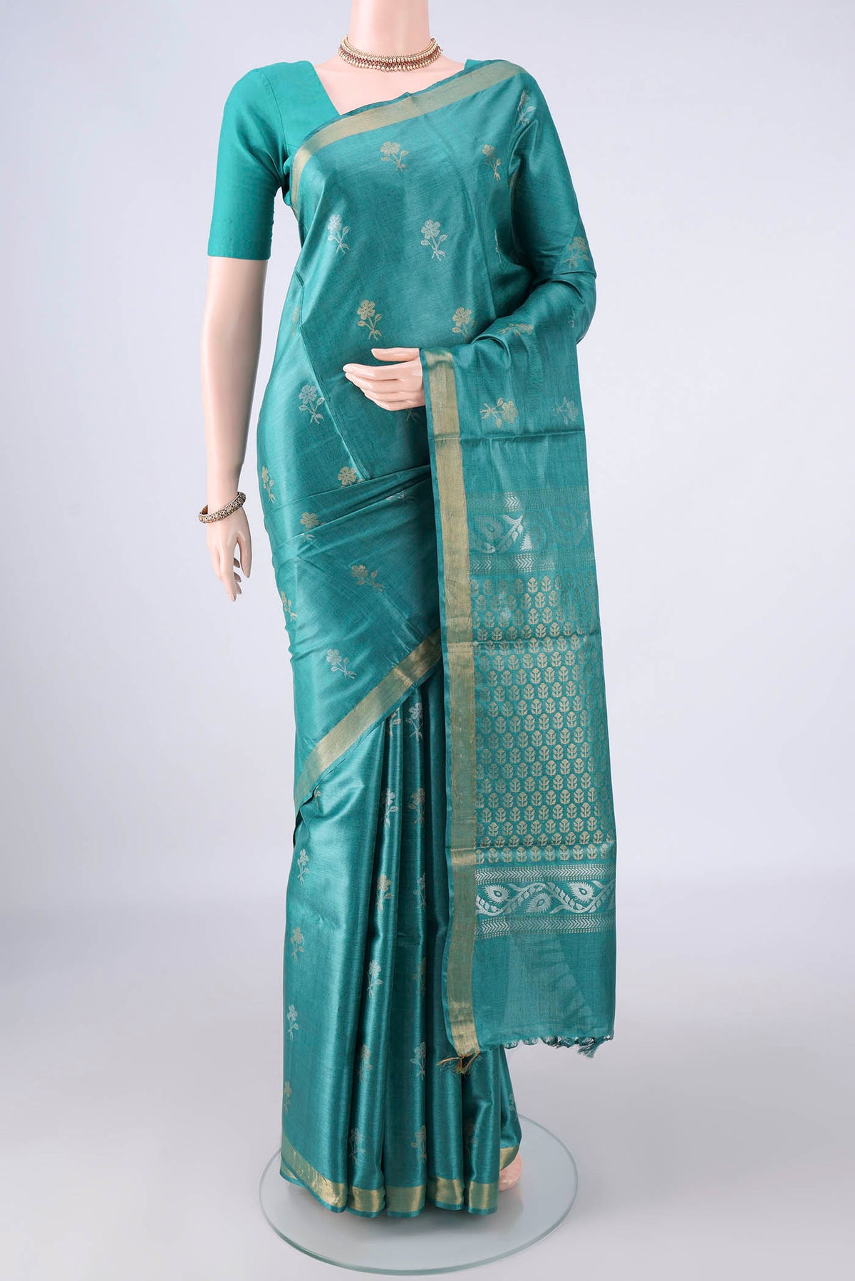 Sea Green Tussar Saree with Zari Butta on the body and Zari Border.  displayed on a mannequin