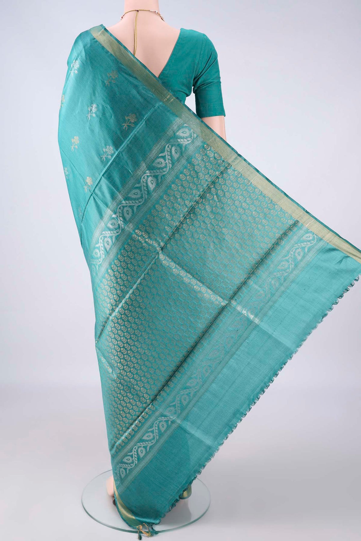 Flat view of Sea Green Tussar Saree with Zari Butta on the body and Zari Border. 