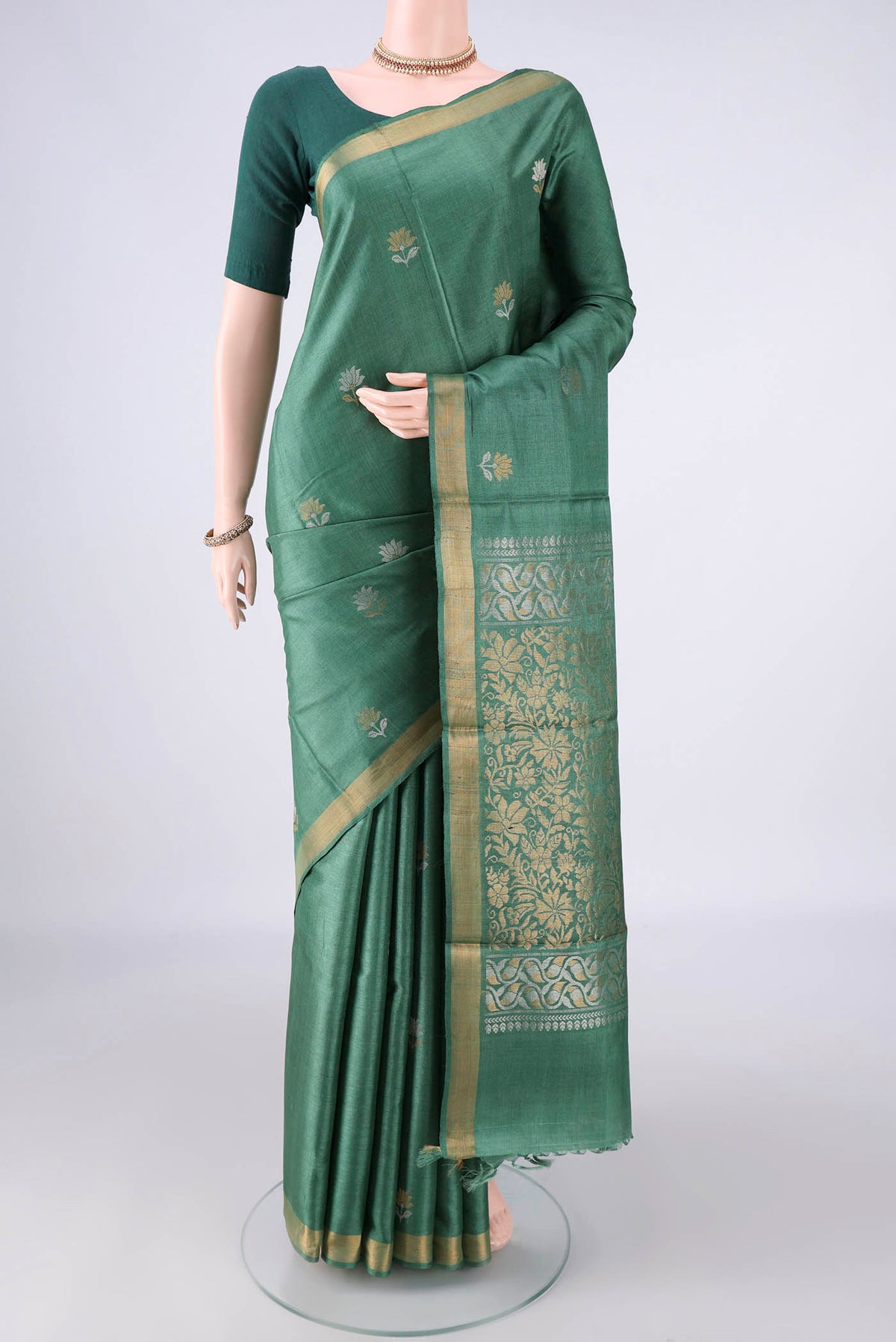 Green MP Tussar Saree with Zari Butta on the body and Zari Border.  displayed on a mannequin