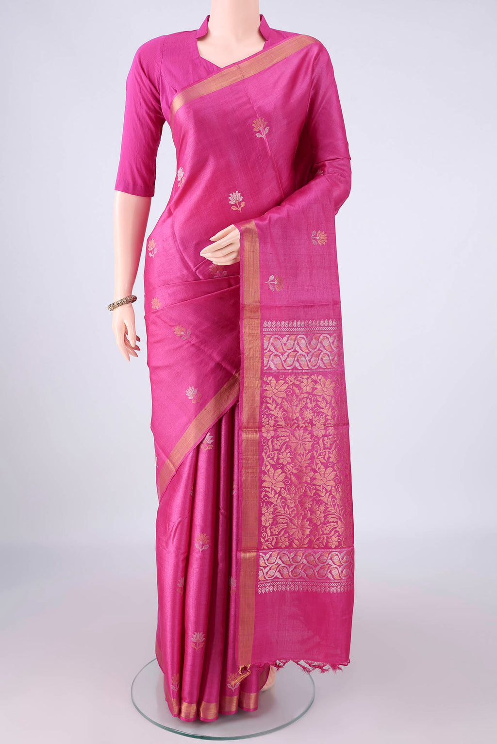Rani Pink Tussar Saree with Zari Butta on the body and Zari Border.  displayed on a mannequin