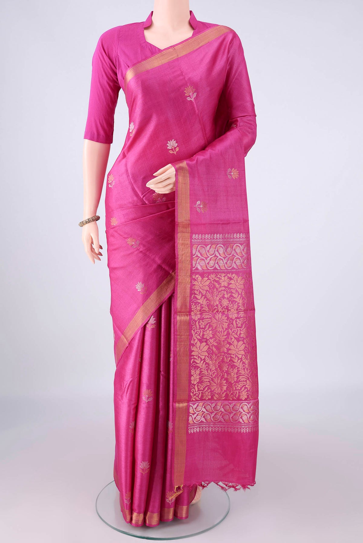 Rani Pink Tussar Saree with Zari Butta on the body and Zari Border.  displayed on a mannequin