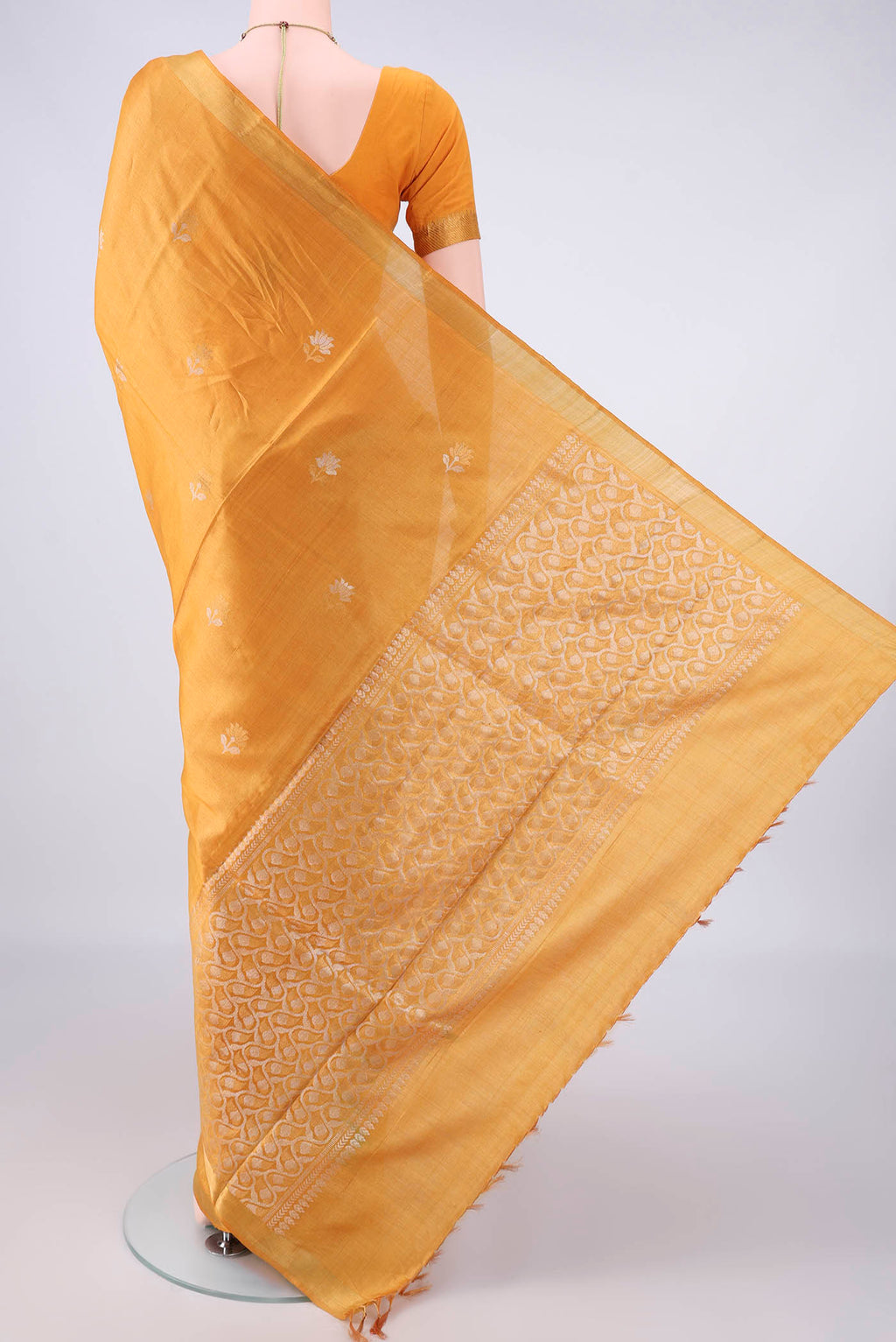 Flat view of Mustard MP Tussar Saree with Zari Butta on the body and Zari Border. 