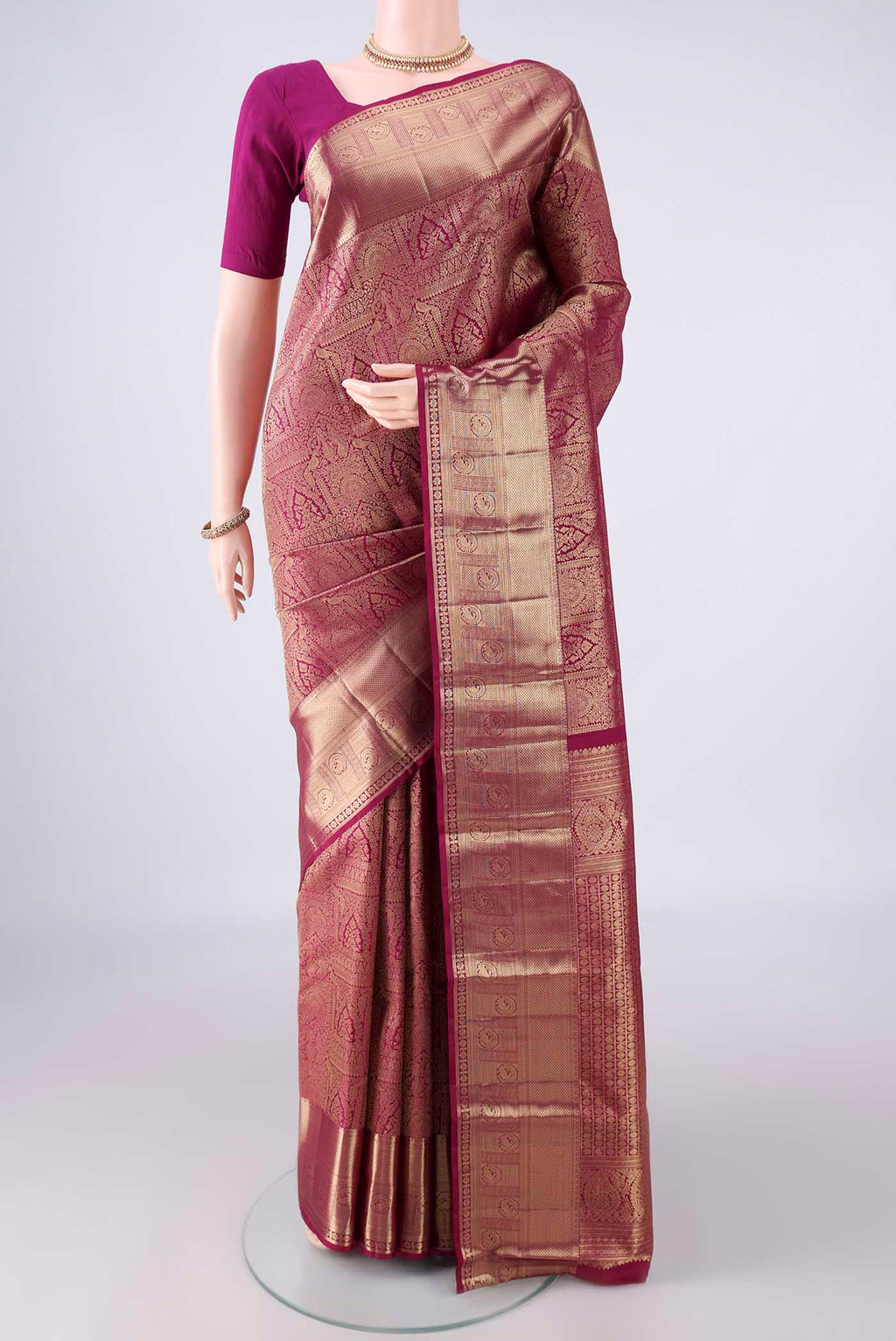 Pure Silk Magenta Kanchipuram Saree with Zari Brocade on the body and Zari Border.  displayed on a mannequin