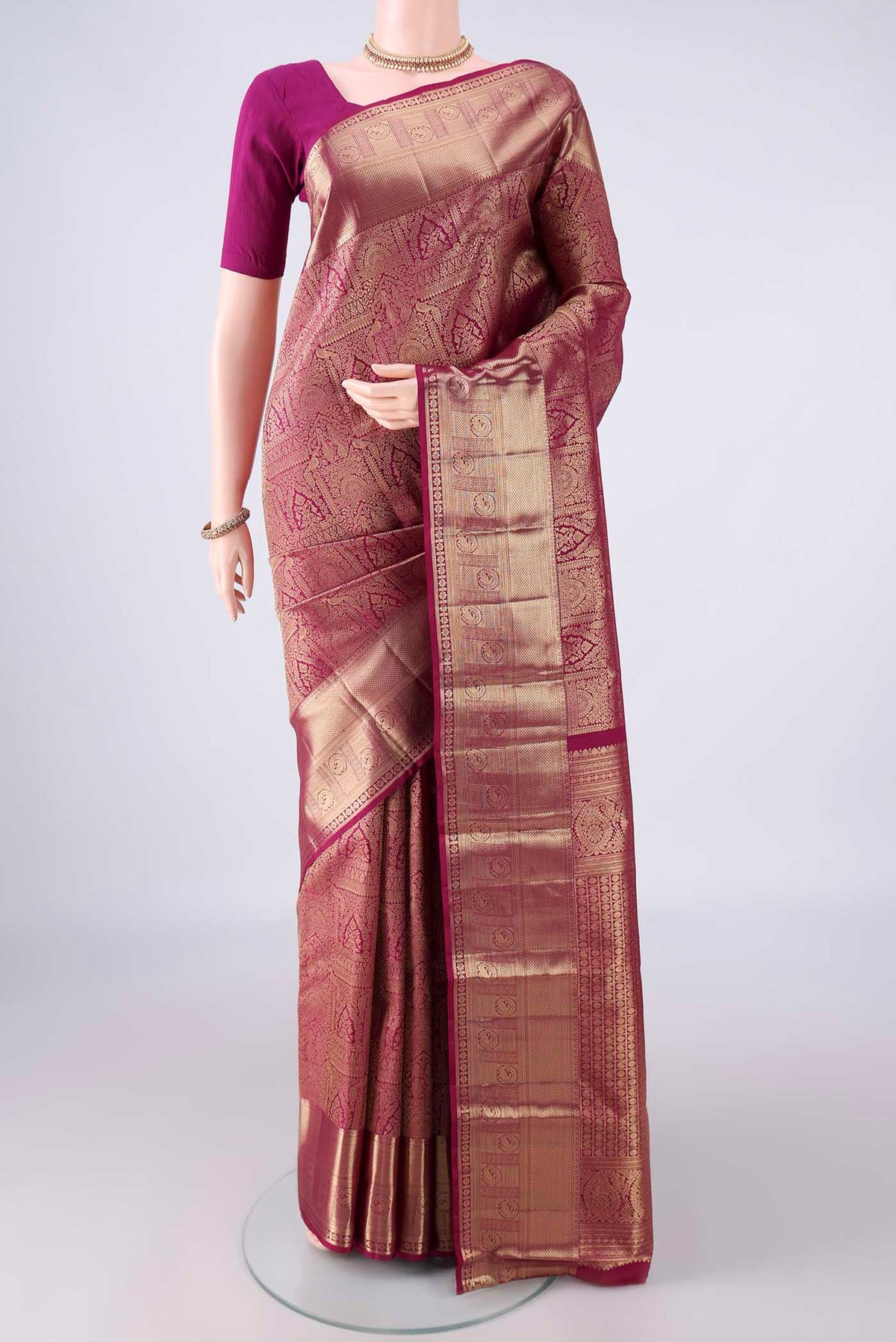 Pure Silk Magenta Kanchipuram Saree with Zari Brocade on the body and Zari Border.  displayed on a mannequin