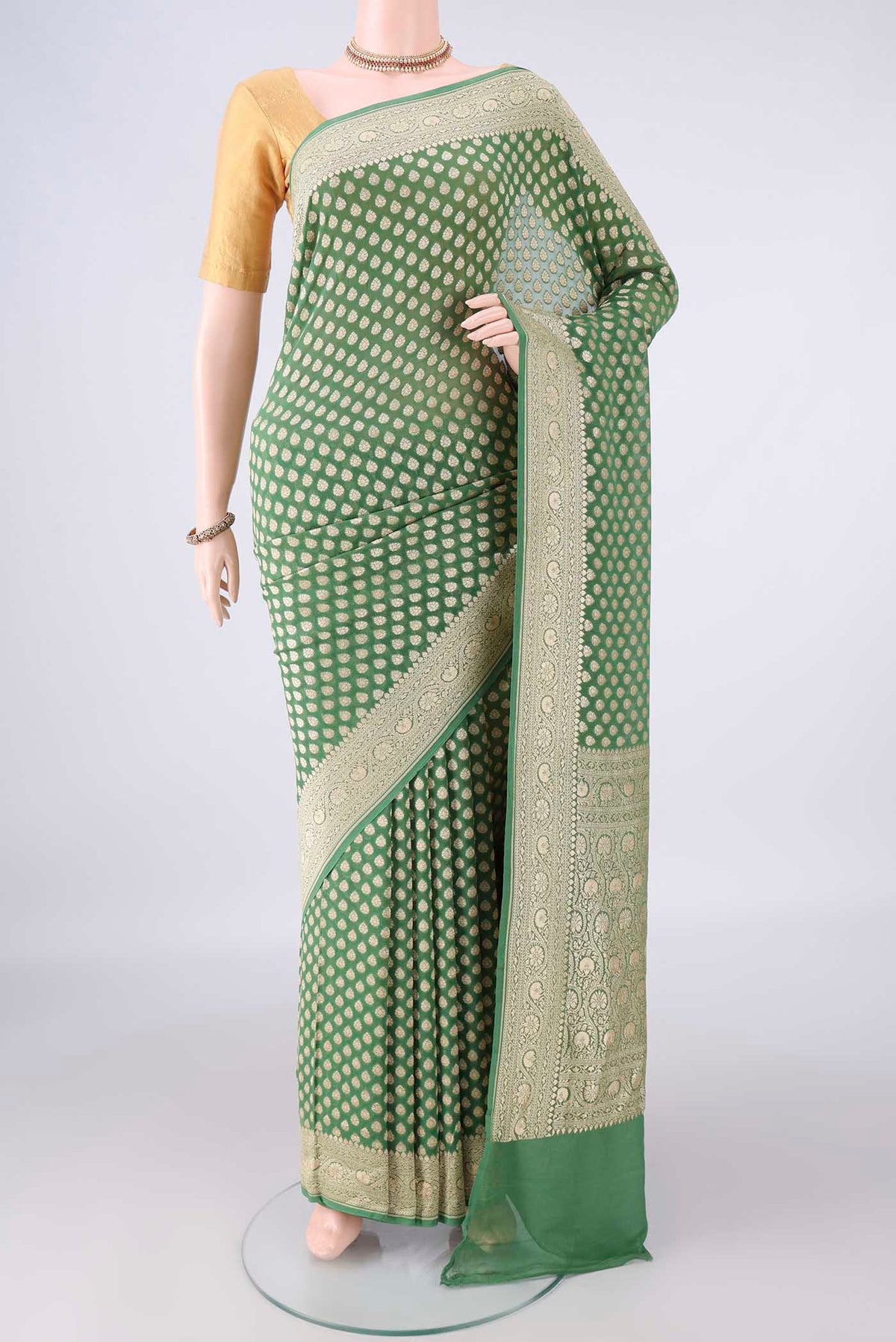 Green Banarasi Georgette Saree with Zari Butta on the body and Zari Border.  displayed on a mannequin