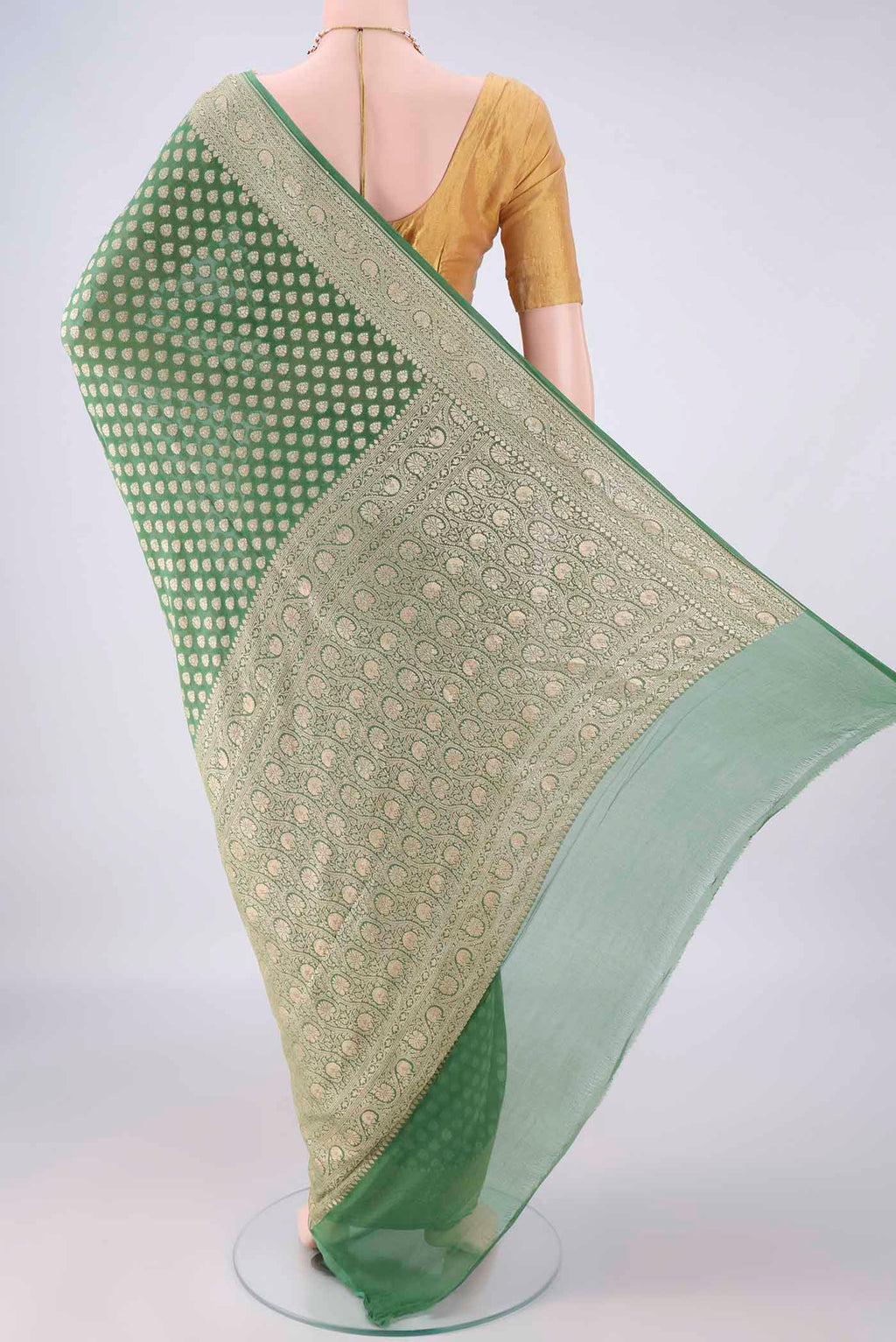 Flat view of Green Banarasi Georgette Saree with Zari Butta on the body and Zari Border. 