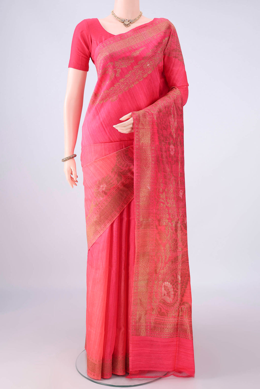 Coral Banarasi Tussar Saree with Zari Butta on the body and Zari Border.  displayed on a mannequin