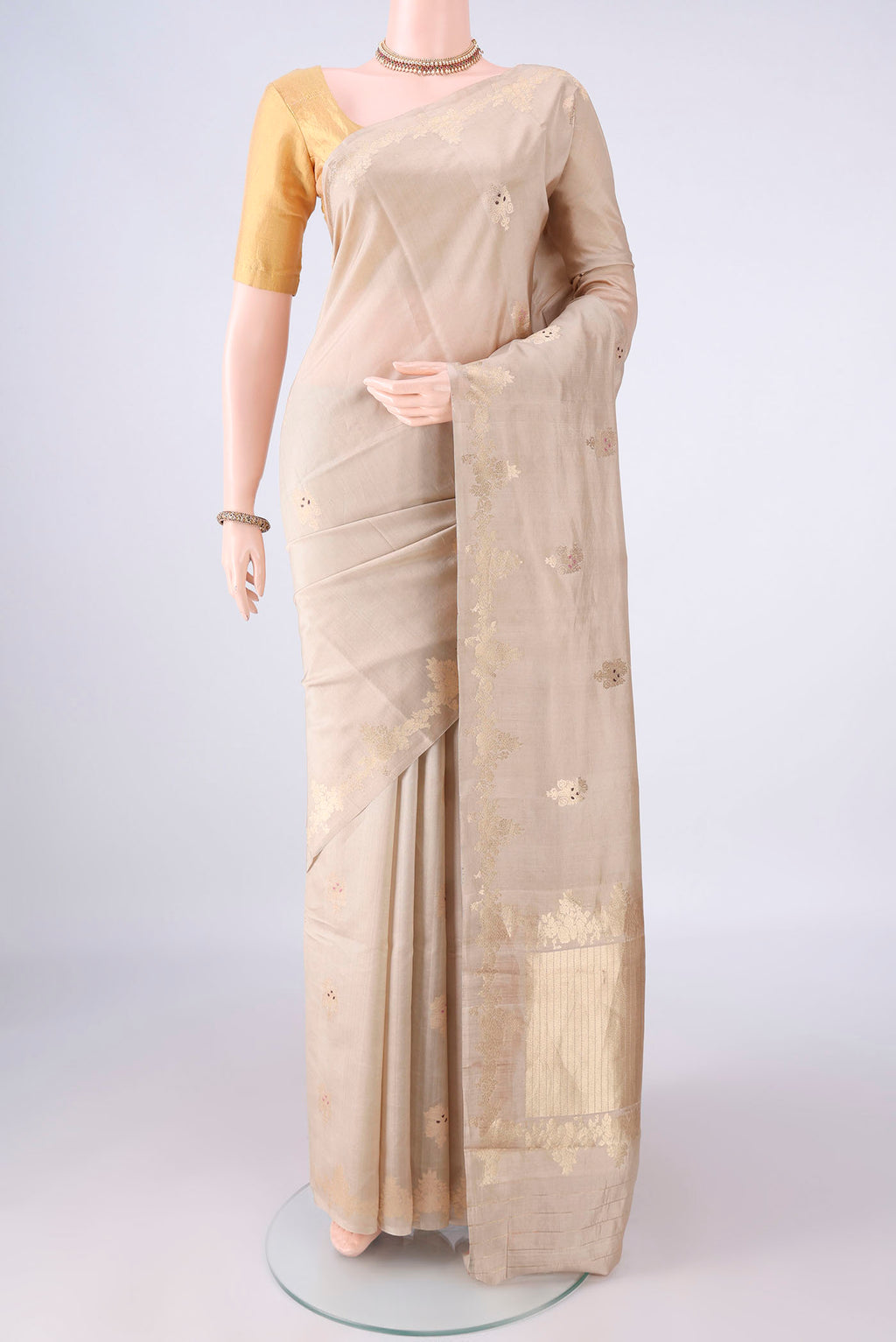 Pure Silk Beige Banarasi Katan Saree with Zari And Thread Butta on the body and Zari Border.  displayed on a mannequin
