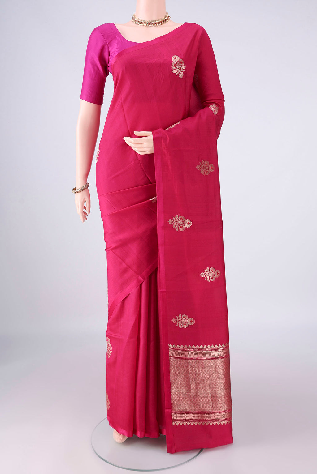 Pure Silk Rani Pink Banarasi Katan Saree with Zari And Thread Butta on the body and Without Border.  displayed on a mannequin