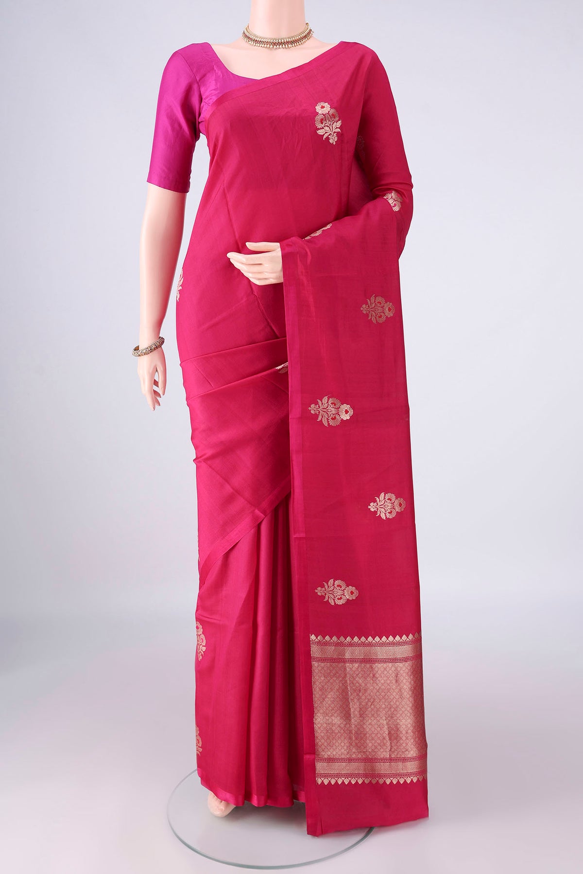 Pure Silk Rani Pink Banarasi Katan Saree with Zari And Thread Butta on the body and Without Border.  displayed on a mannequin
