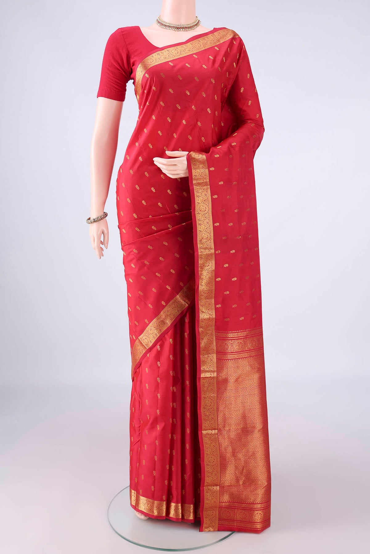 Pure Silk Red Kanjivaram Saree with Zari Butta on the body and Zari Border.  displayed on a mannequin