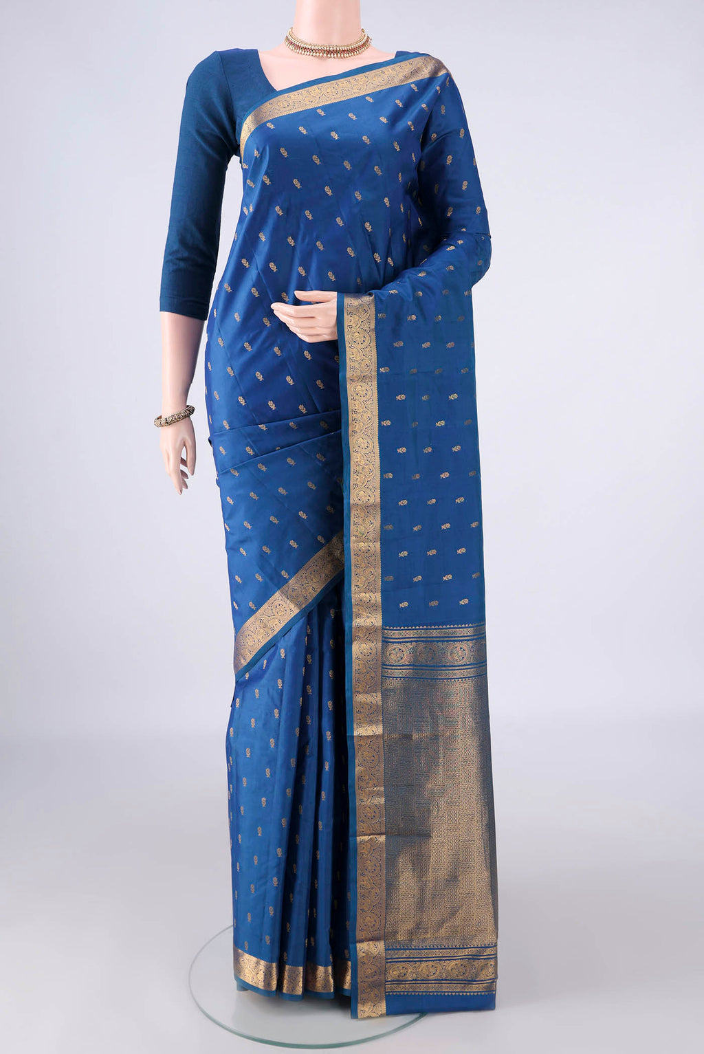 Pure Silk Blue Kanjivaram Saree with Zari Butta on the body and Zari Border.  displayed on a mannequin
