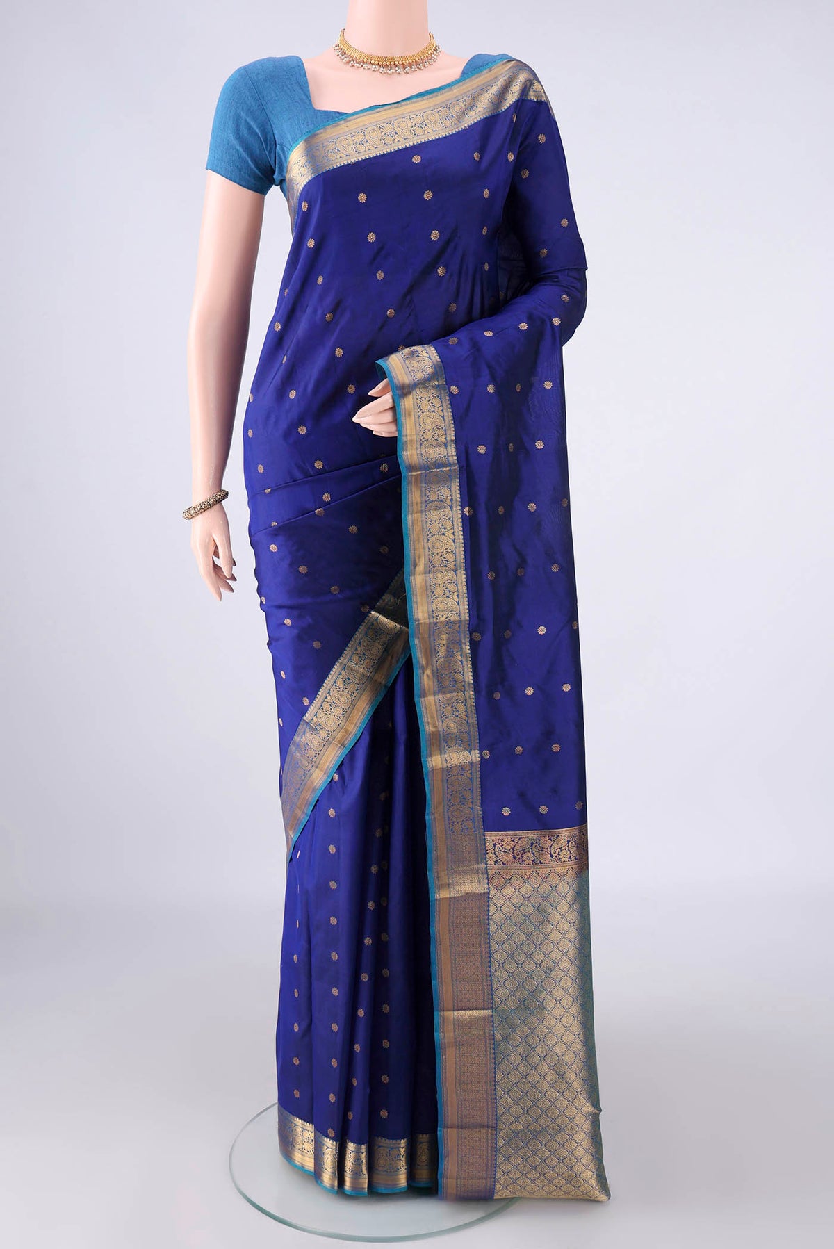 Pure Silk Dark Blue Kanjivaram Saree with Zari Butta on the body and Zari Border.  displayed on a mannequin