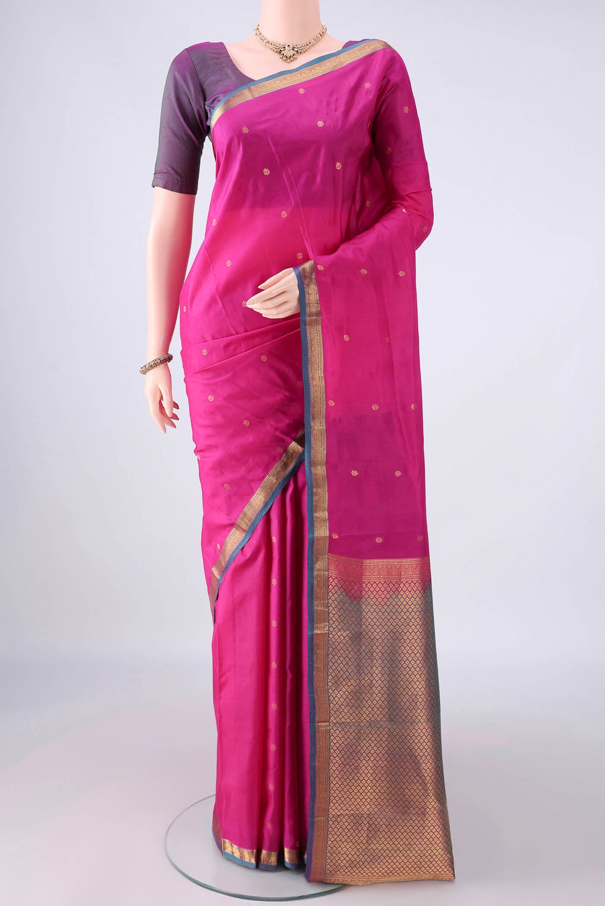 Pure Silk Rani Pink Kanjivaram Saree with Zari Butta on the body and Zari Border.  displayed on a mannequin