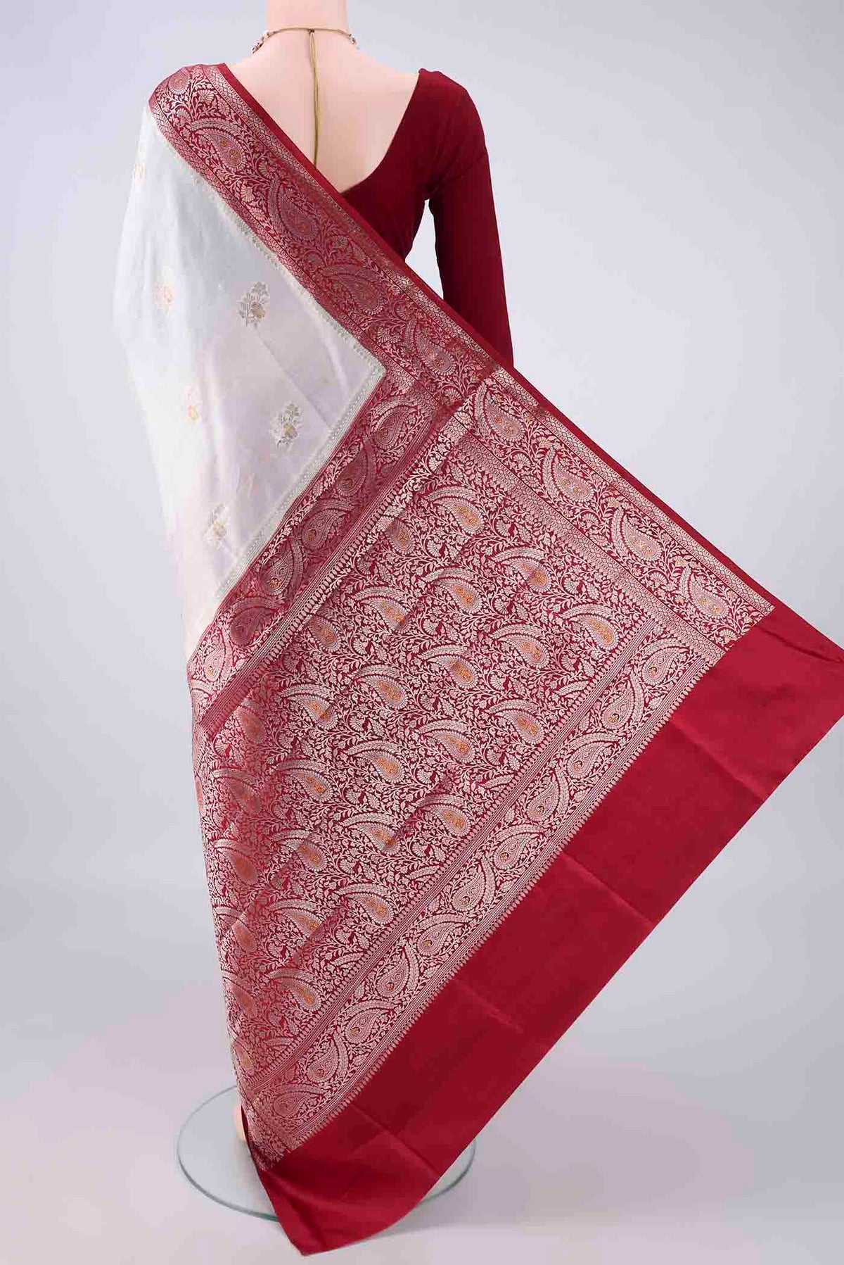Flat view of Pure Silk White Banarasi Raw Saree with Zari Butta on the body and Zari Border. 