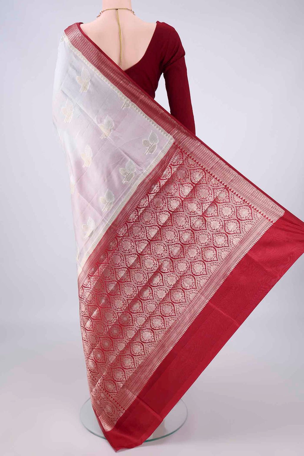Flat view of Pure Silk White Banarasi Raw Saree with Zari Butta on the body and Zari Border. 