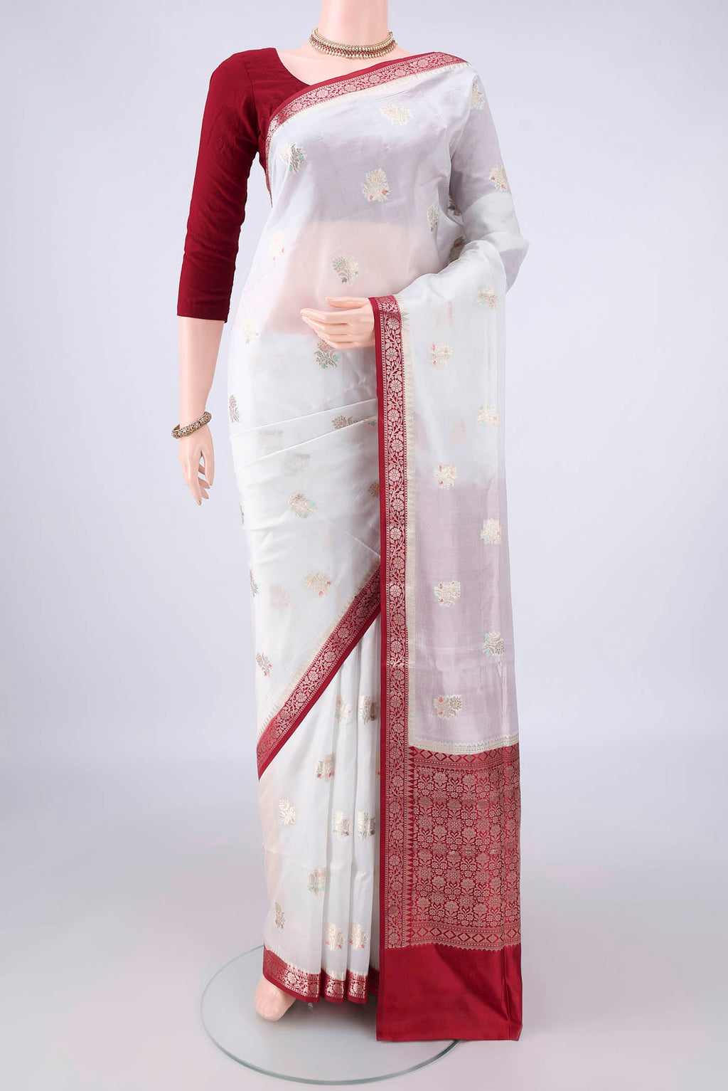 Pure Silk White Banarasi Raw Saree with Zari And Thread Butta on the body and Zari Border.  displayed on a mannequin
