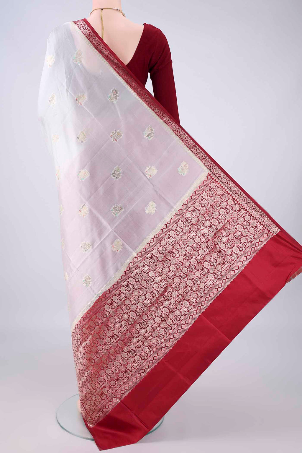 Flat view of Pure Silk White Banarasi Raw Saree with Zari And Thread Butta on the body and Zari Border. 