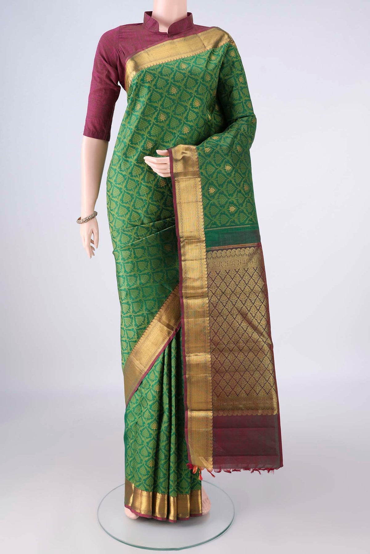 Pure Silk Green Kanjivaram Saree with Jacquard With Zari Butta on the body and Zari Border.  displayed on a mannequin