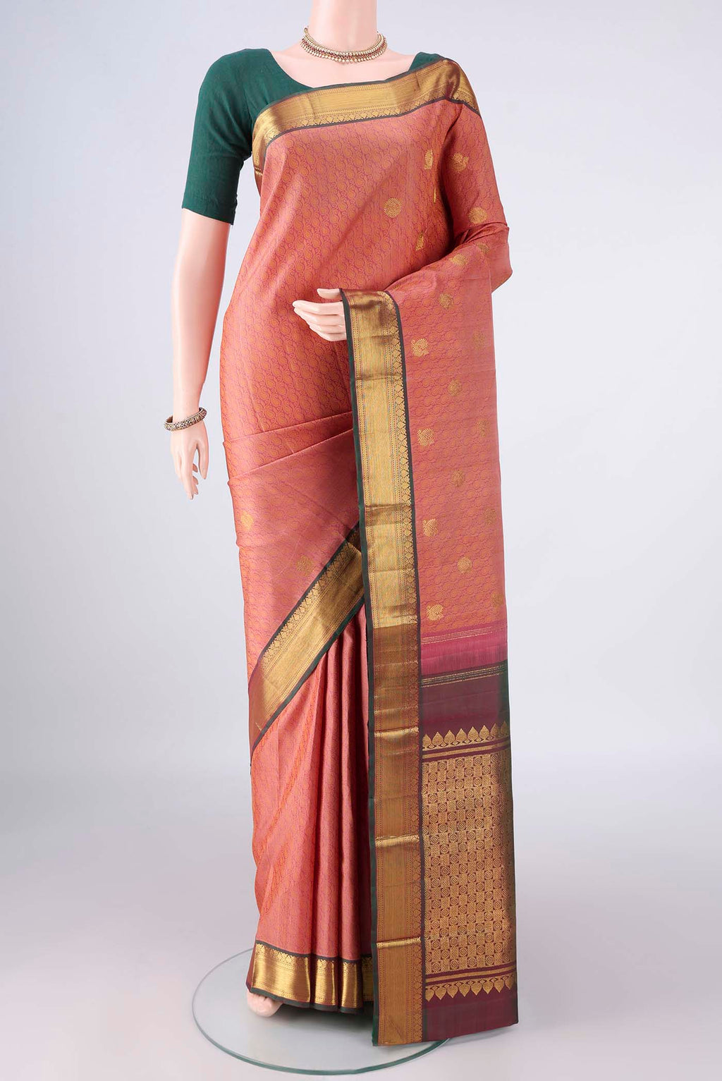 Pure Silk Coral Kanjivaram Saree with Jacquard With Zari Butta on the body and Zari Border.  displayed on a mannequin
