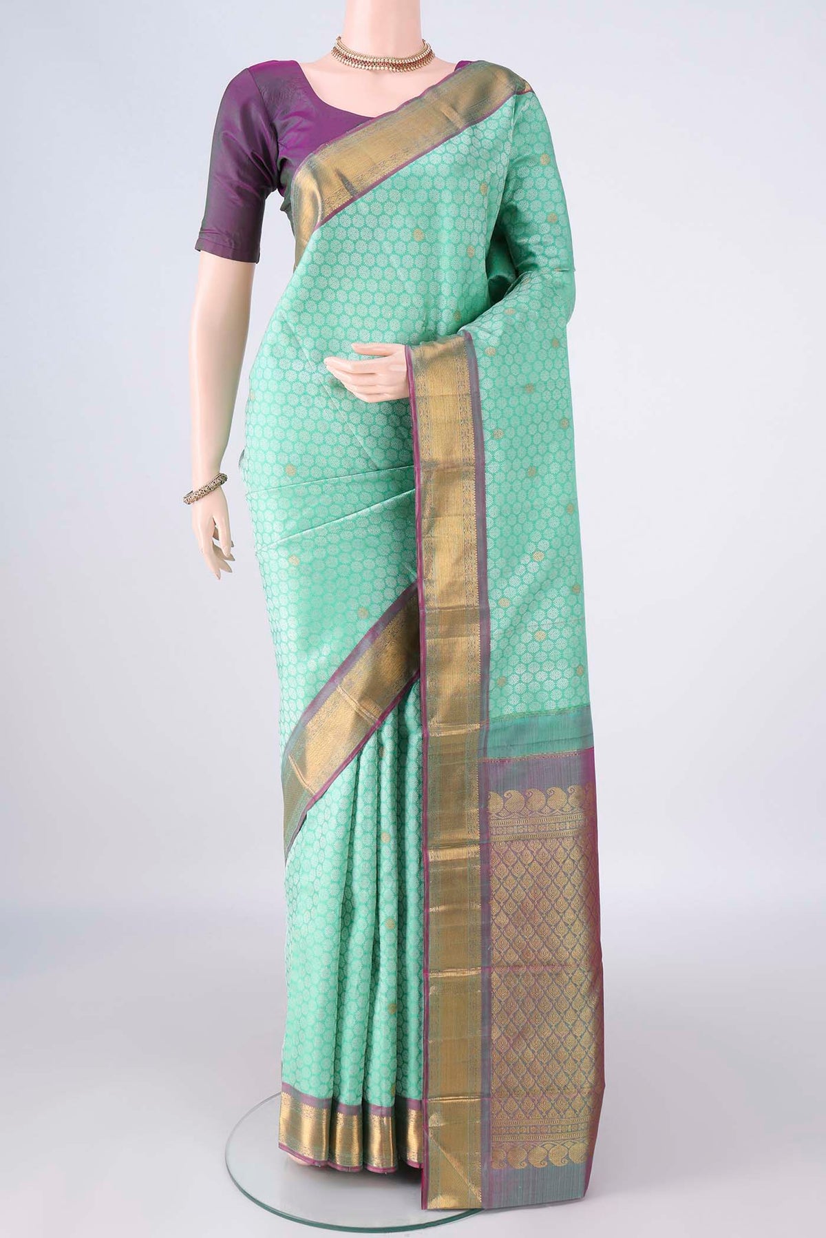 Pure Silk Mint Green Kanjivaram Saree with Jacquard With Zari Butta on the body and Zari Border.  displayed on a mannequin
