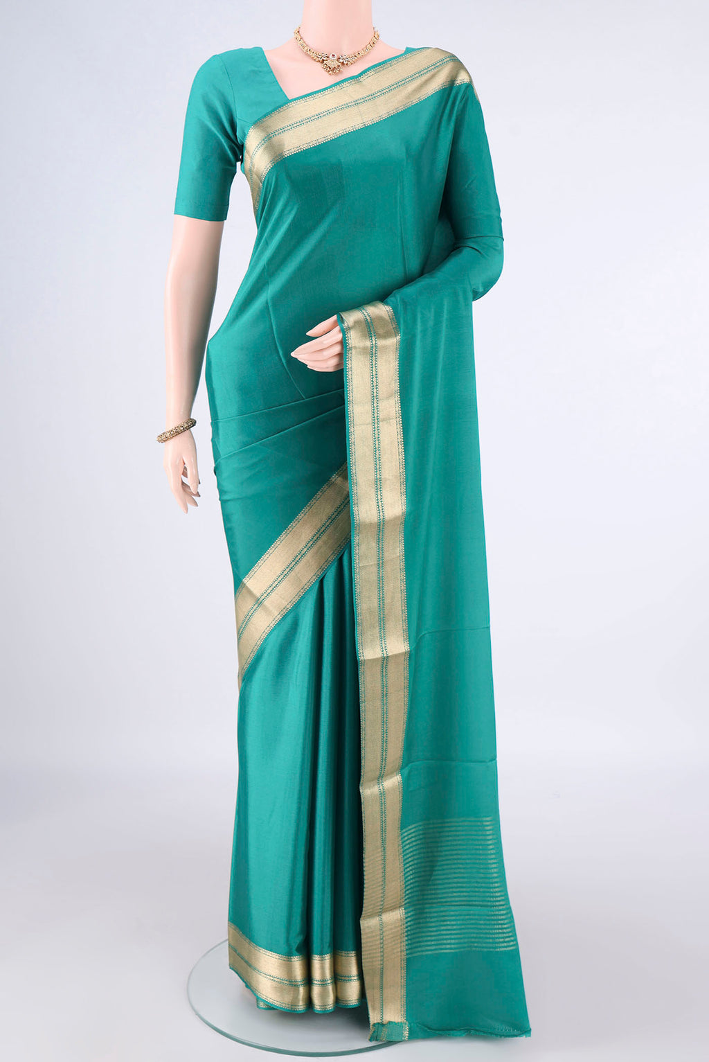 Sea Green Mysore Crepe Saree with Plain Body and Zari Border.  displayed on a mannequin
