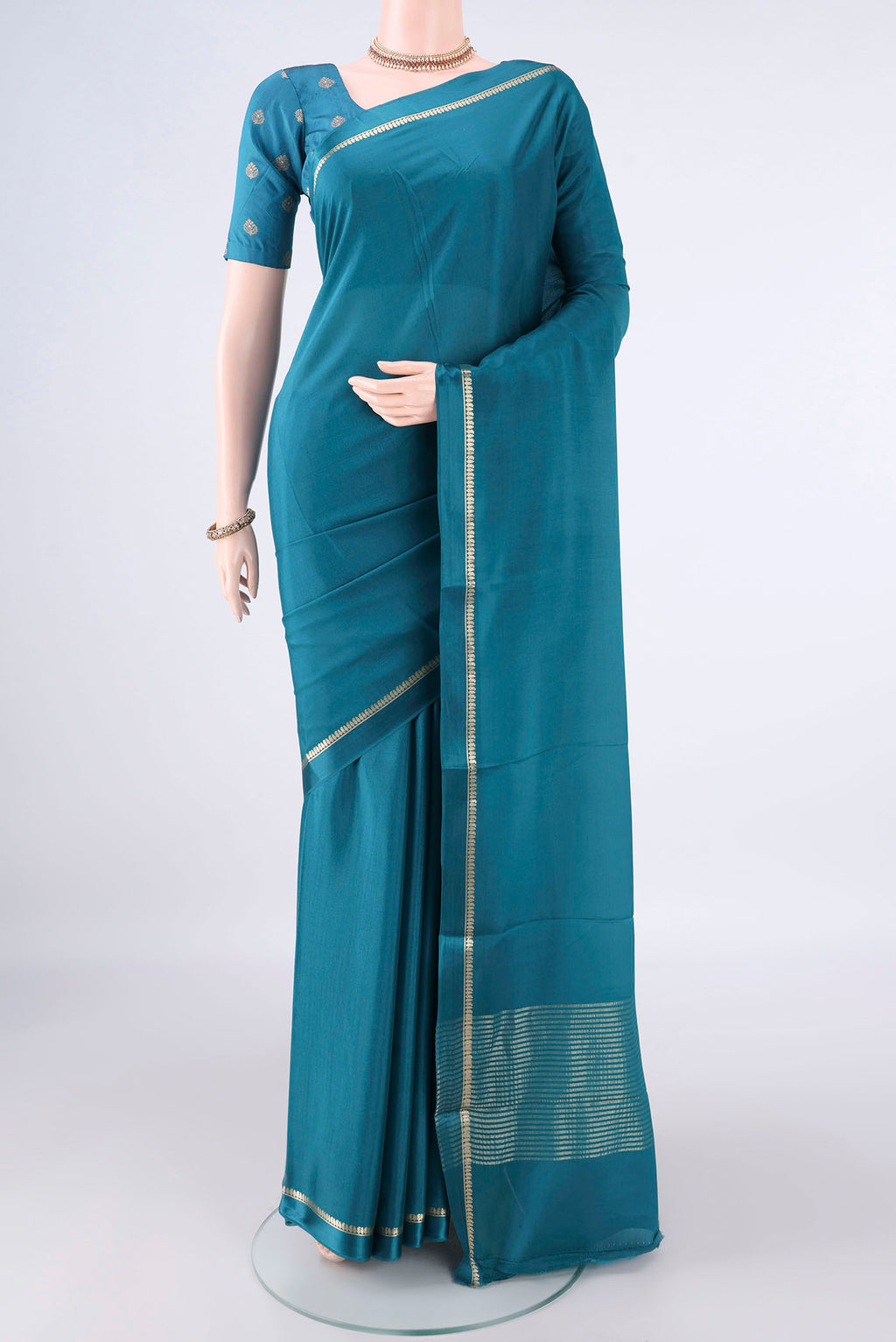 Teal Mysore Crepe Saree with Plain Body and Zari Border.  displayed on a mannequin