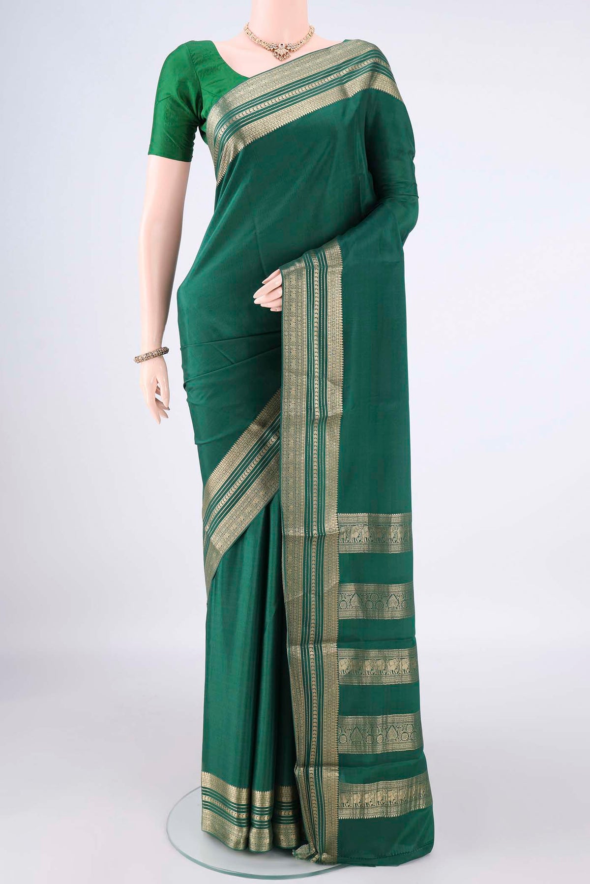Bottle Green Mysore Crepe Saree with Plain Body and Zari Border.  displayed on a mannequin