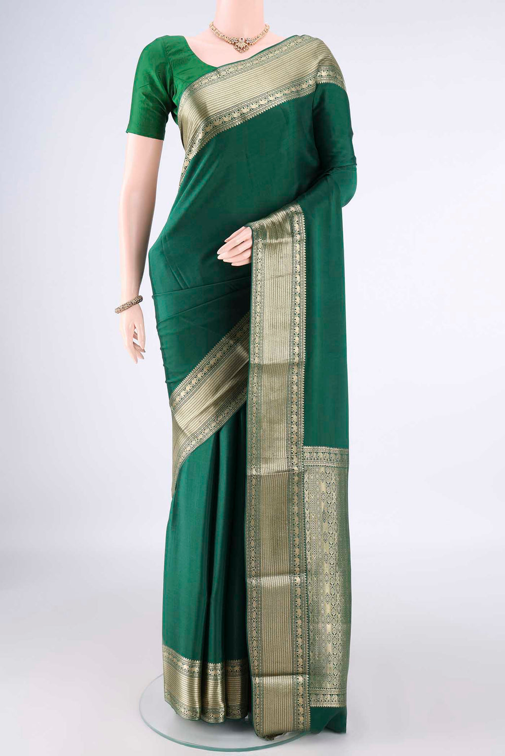 Green Mysore Crepe Saree with Plain Body and Zari Border.  displayed on a mannequin