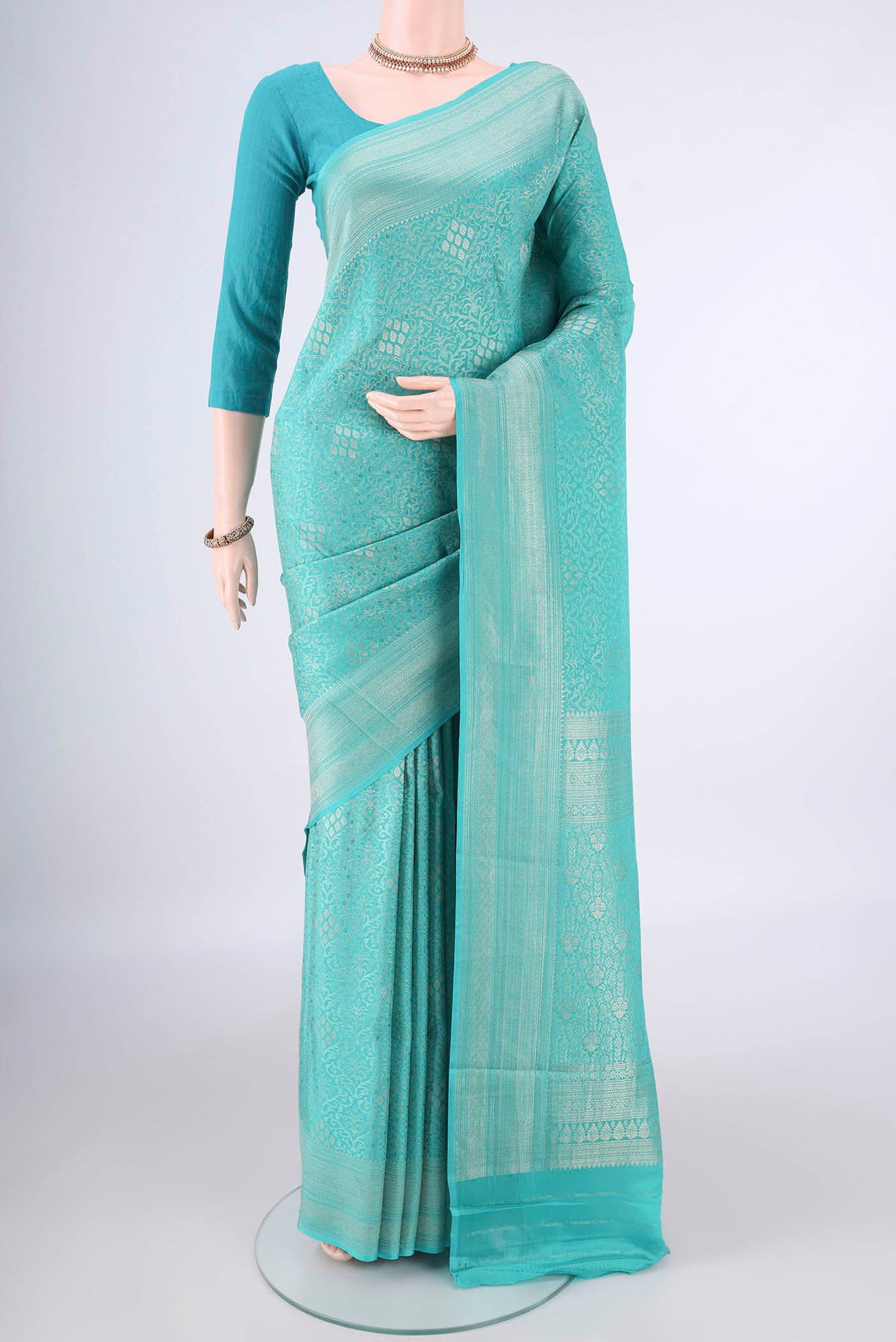 Turquoise Mysore Crepe Saree with Zari Brocade on the body and Zari Border.  displayed on a mannequin
