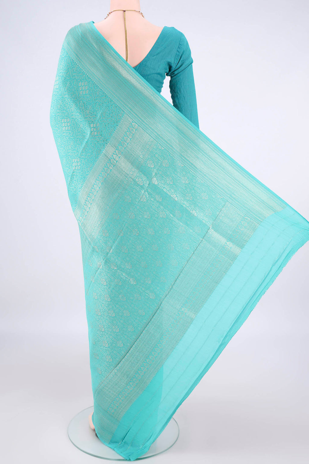 Flat view of Turquoise Mysore Crepe Saree with Zari Brocade on the body and Zari Border. 