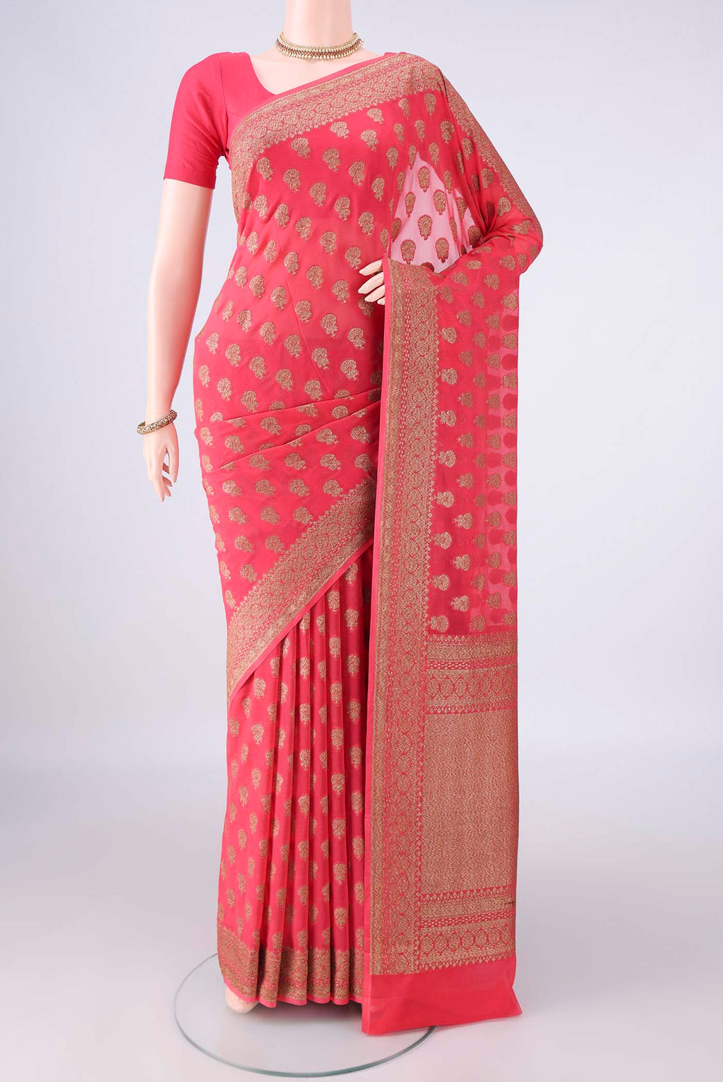 Coral Banarasi Georgette Saree with Zari Butta on the body and Zari Border.  displayed on a mannequin