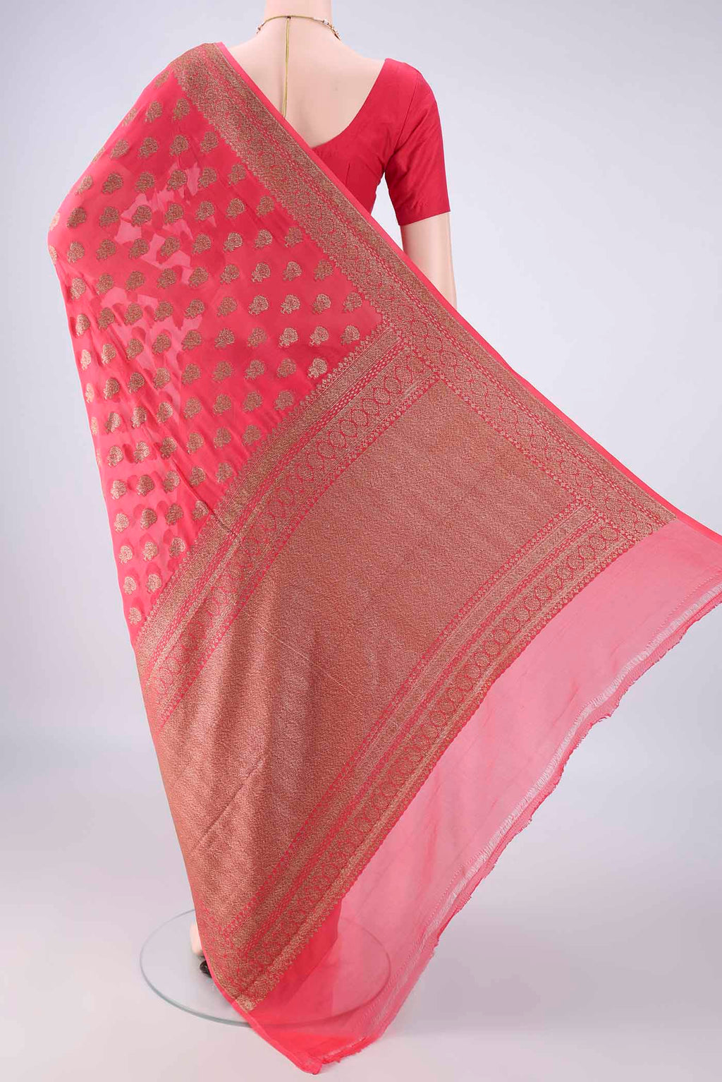 Flat view of Coral Banarasi Georgette Saree with Zari Butta on the body and Zari Border. 