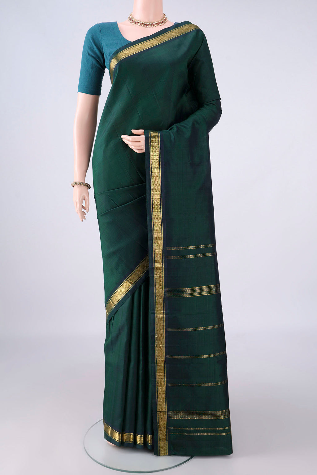 Pure Silk Bottle Green Kanjivaram Saree with Plain Body and Zari Border.  displayed on a mannequin