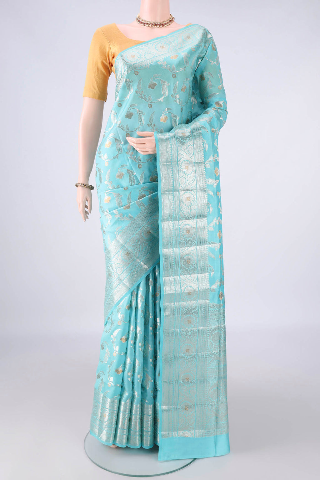 Pure Silk Sky Blue Banarasi Raw Saree with Zari Butta on the body and Zari Border.  displayed on a mannequin