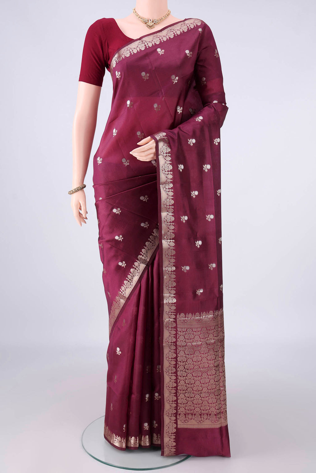 Pure Silk Burgundy Banarasi Raw Saree with Zari Butta on the body and Zari Border.  displayed on a mannequin