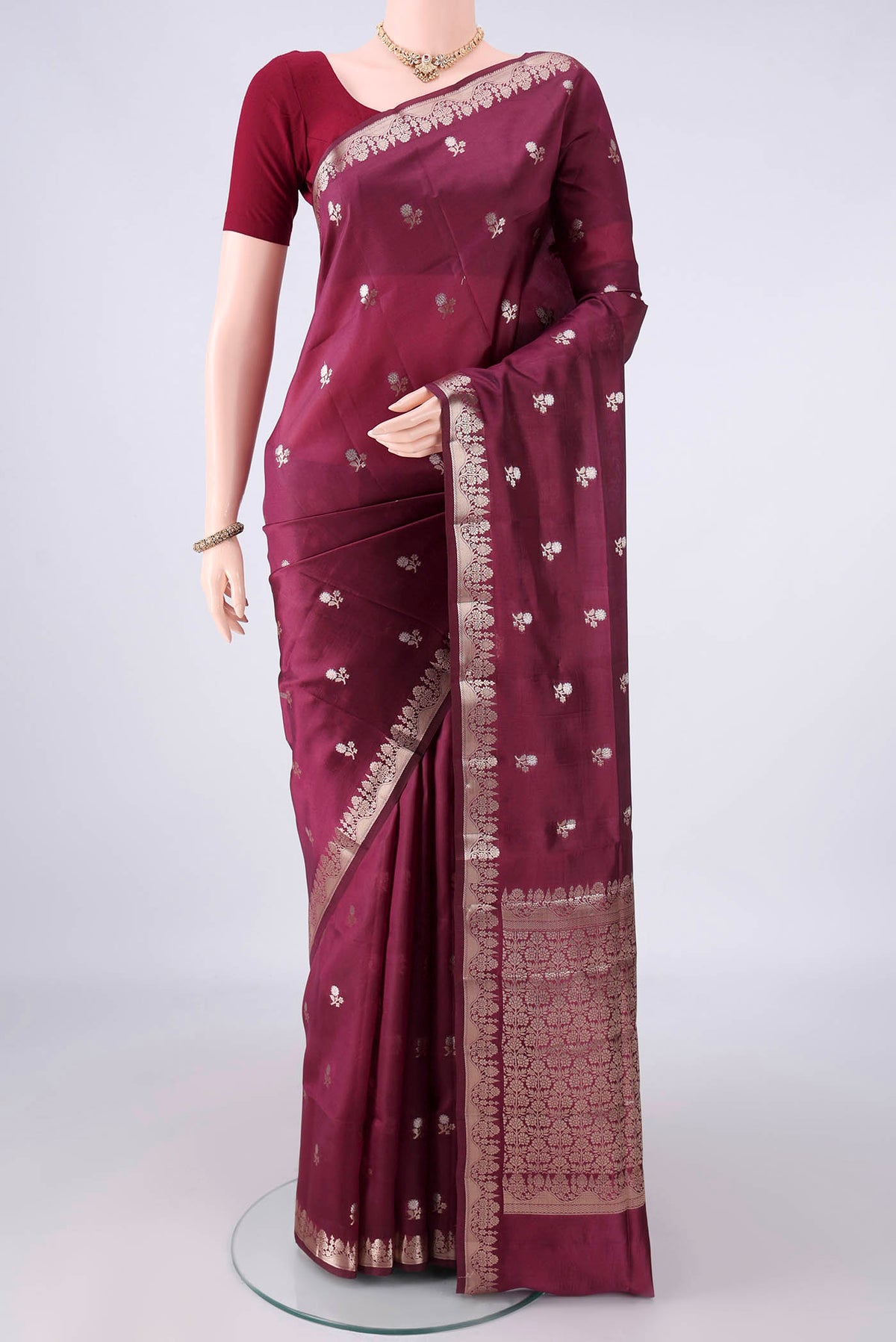 Pure Silk Burgundy Banarasi Raw Saree with Zari Butta on the body and Zari Border.  displayed on a mannequin