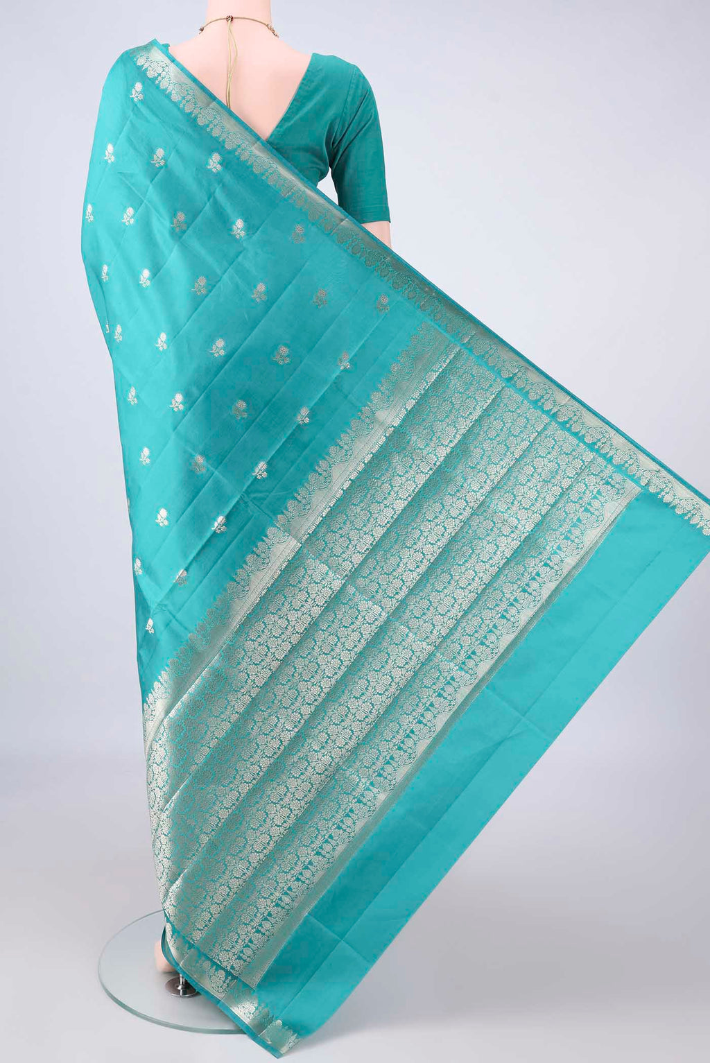 Flat view of Pure Silk Turquoise Banarasi Raw Saree with Zari Butta on the body and Zari Border. 