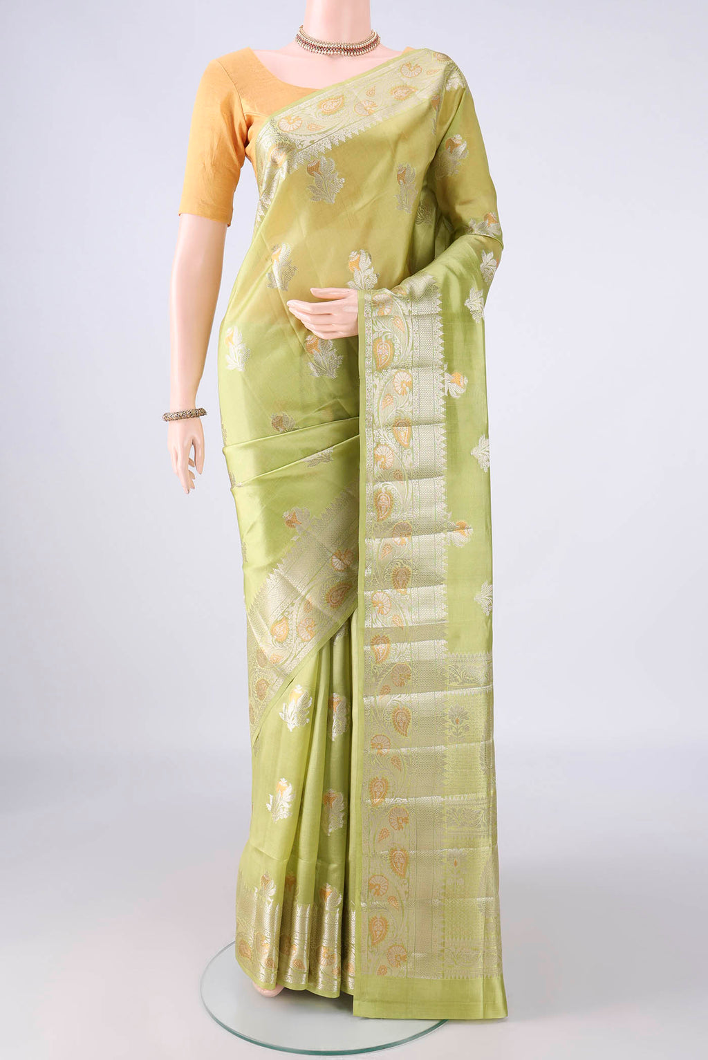 Pure Silk Light Green Banarasi Raw Saree with Zari Butta on the body and Zari Border.  displayed on a mannequin