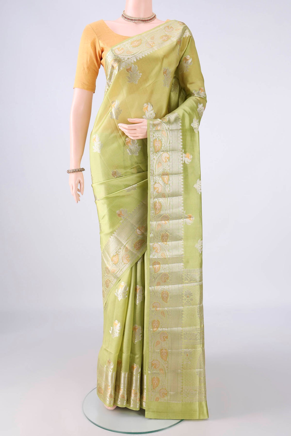 Pure Silk Light Green Banarasi Raw Saree with Zari Butta on the body and Zari Border.  displayed on a mannequin