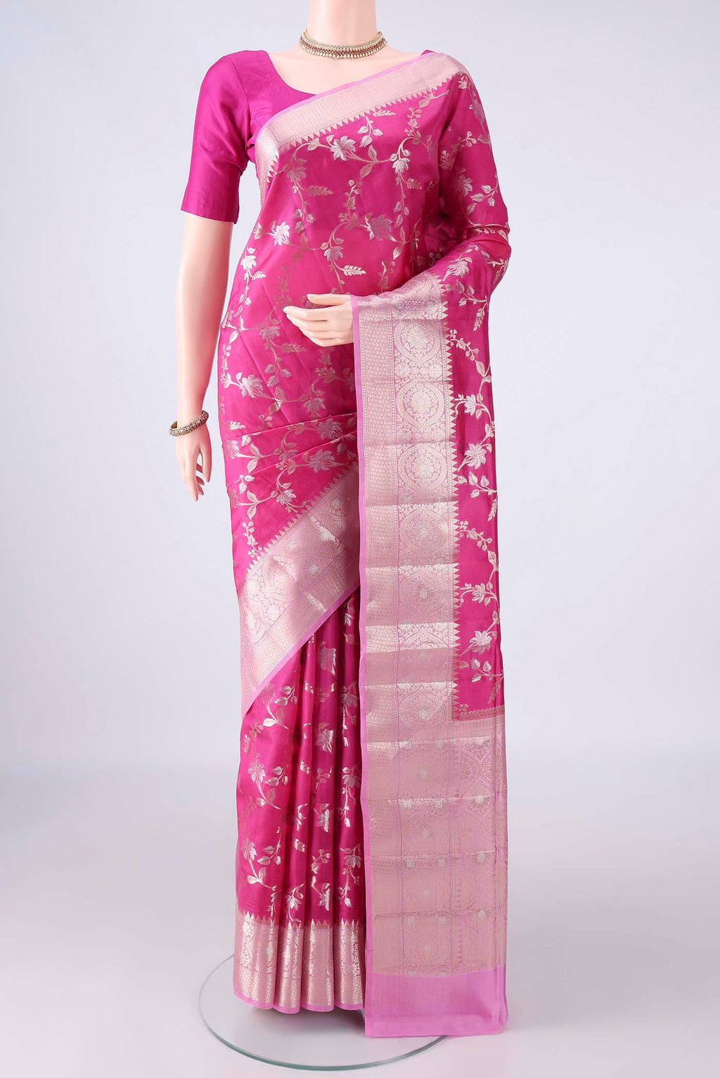 Pure Silk Rani Pink Banarasi Raw Saree with Zari Brocade on the body and Zari Border.  displayed on a mannequin
