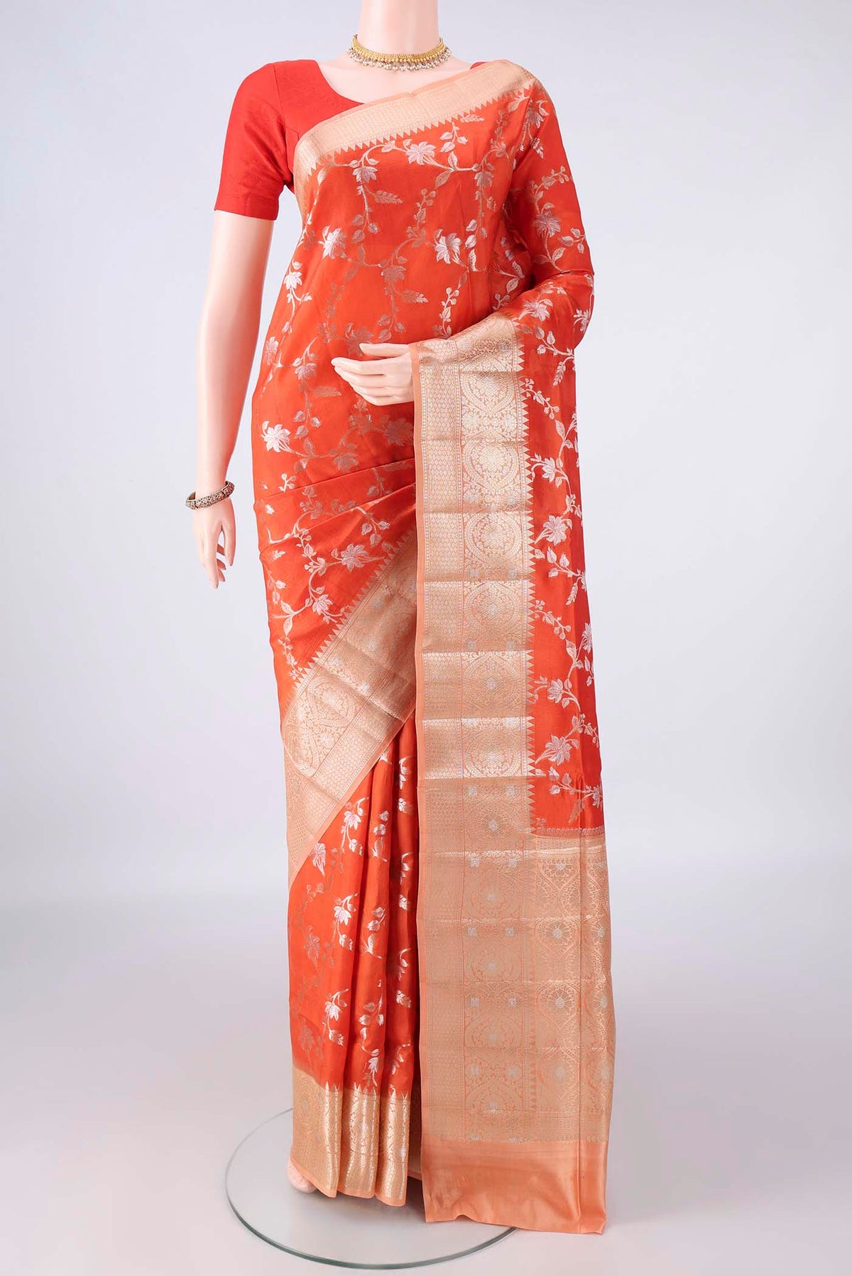 Pure Silk Orange Banarasi Raw Saree with Zari Brocade on the body and Zari Border.  displayed on a mannequin