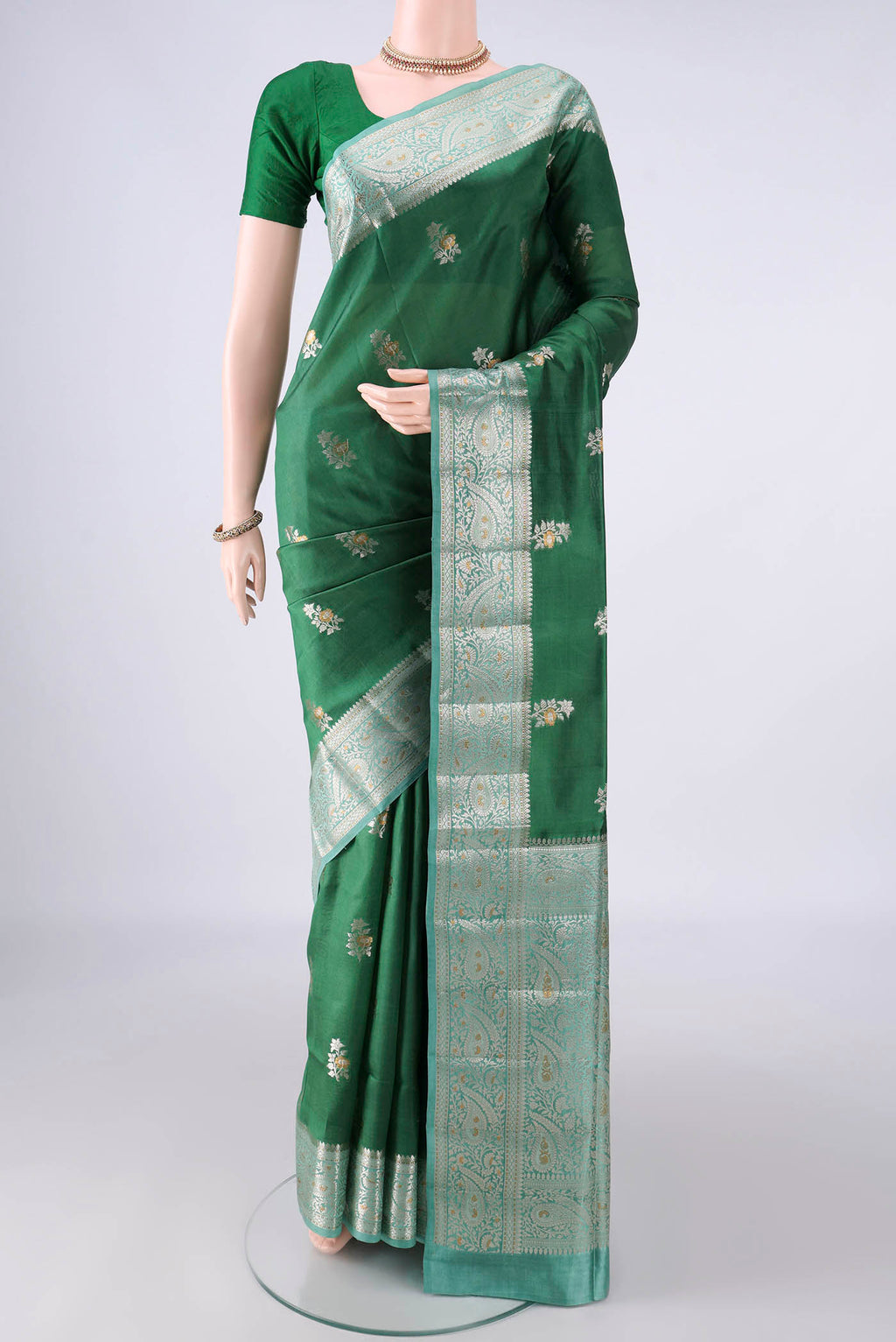 Pure Silk Bottle Green Banarasi Raw Saree with Zari Brocade on the body and Zari Border.  displayed on a mannequin
