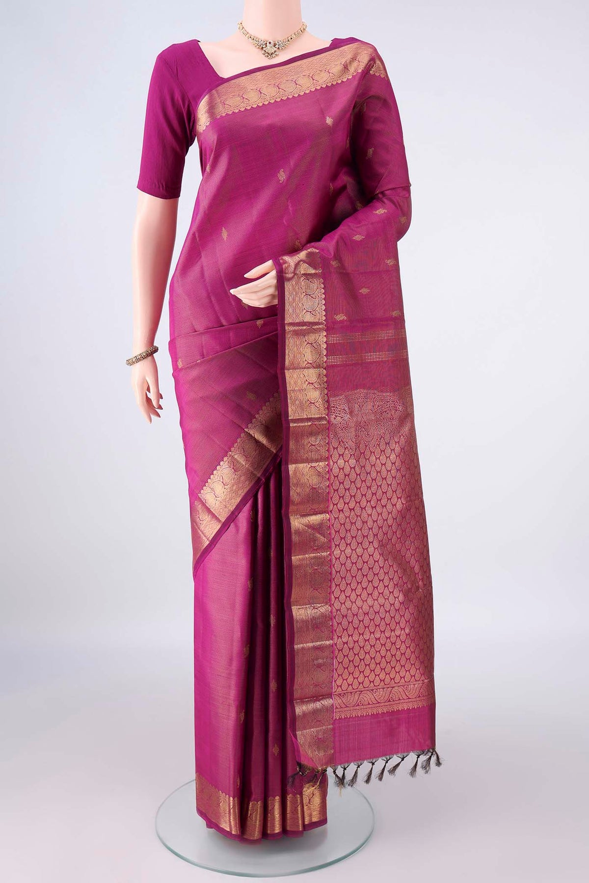 Pure Silk Magenta Kanchipuram Saree with Zari Butta on the body and Zari Border.  displayed on a mannequin