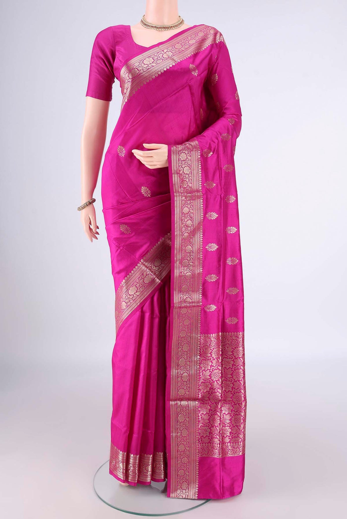 Pure Silk Rani Pink Banarasi Katan Saree with Zari Butta on the body and Zari Border.  displayed on a mannequin