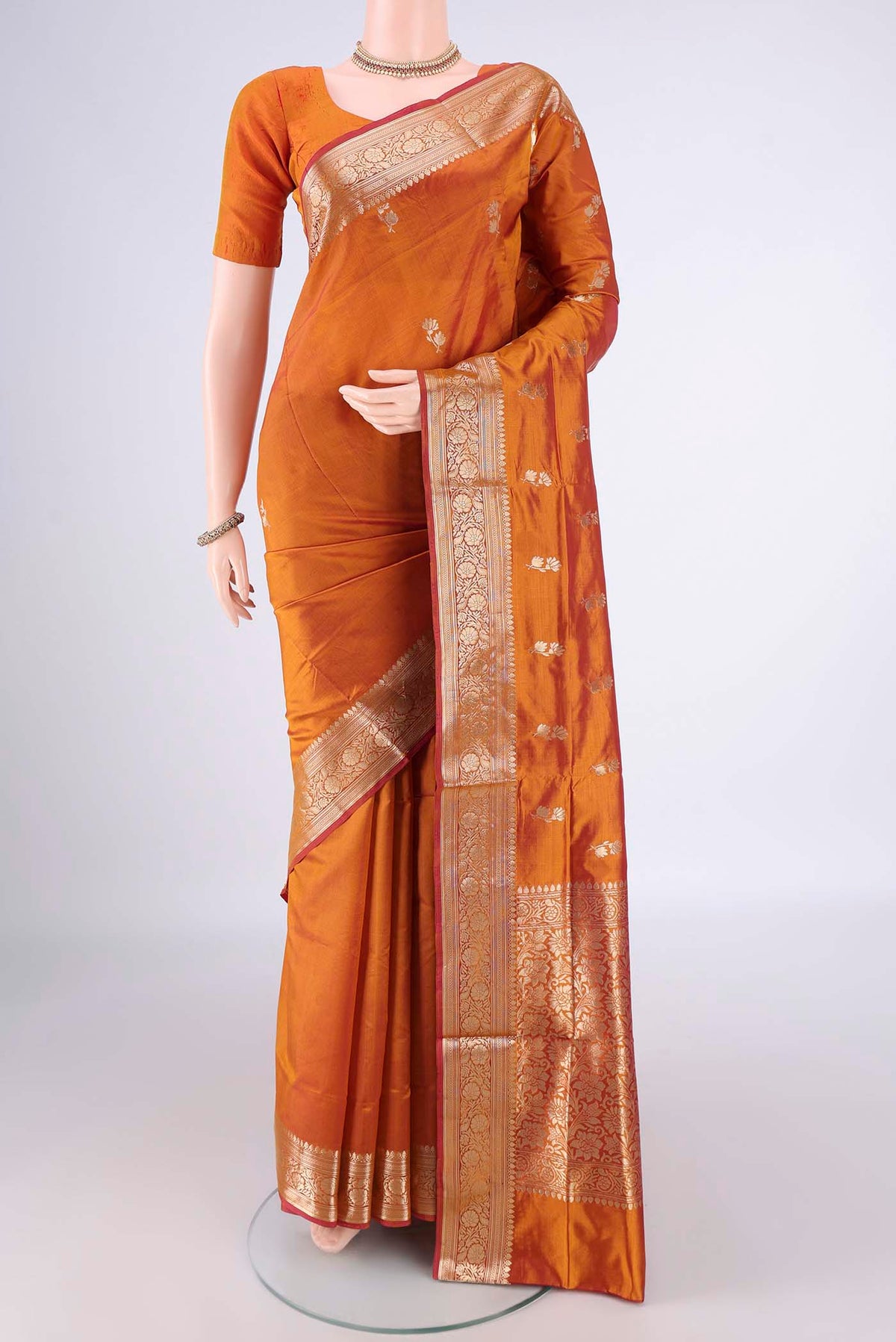 Pure Silk Brick Orange Banarasi Katan Saree with Zari Butta on the body and Zari Border.  displayed on a mannequin